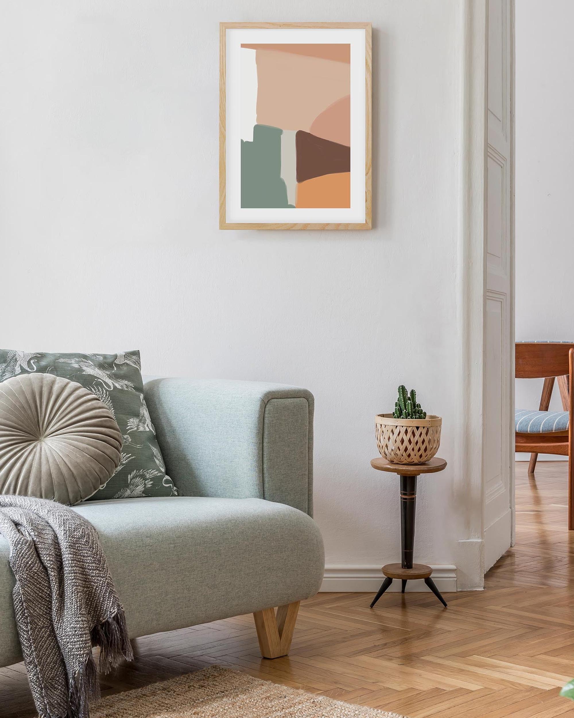 Modern living room with a light blue sofa, abstract art on the wall, and a small plant stand.