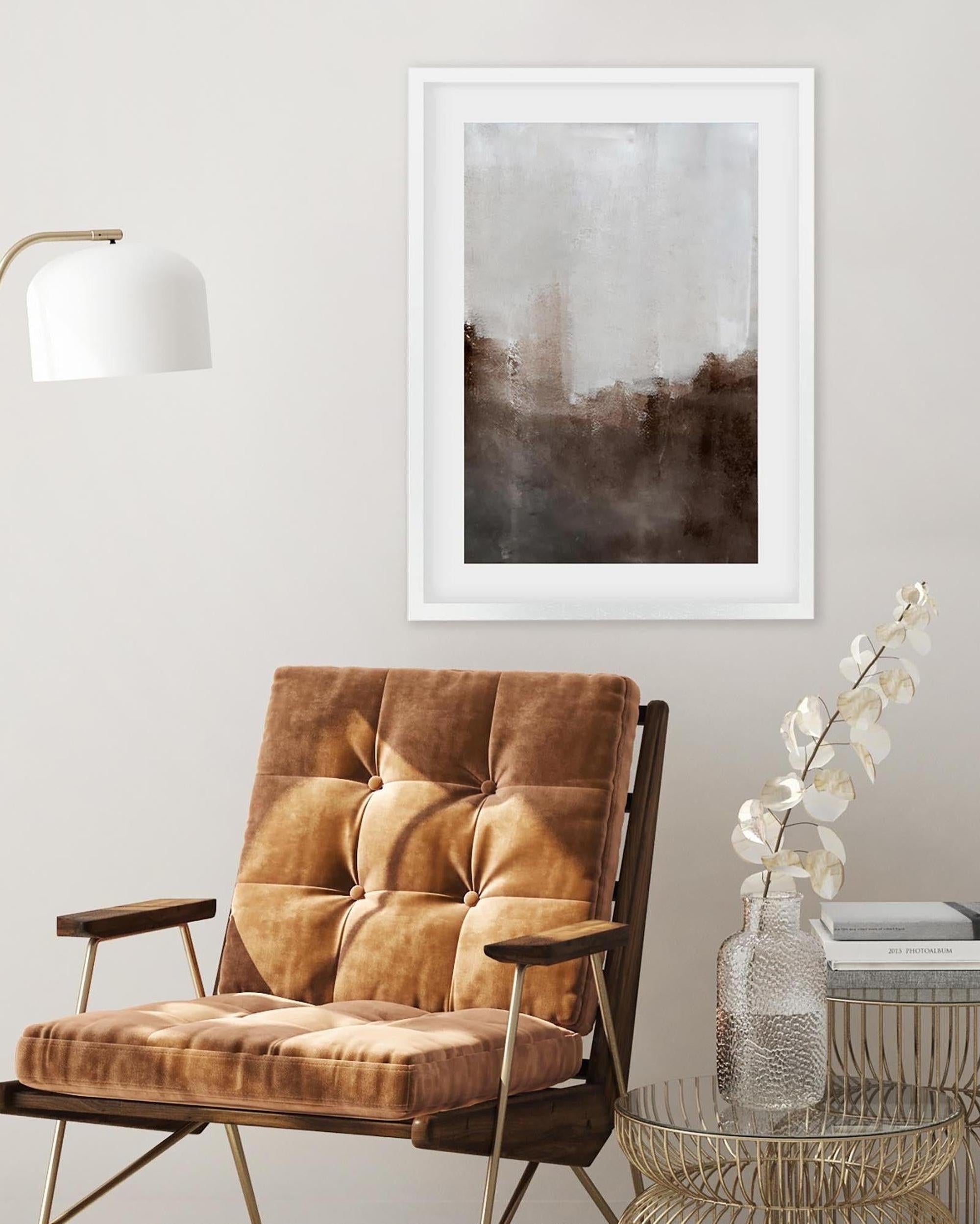 Brown armchair in a room with a framed abstract painting on the wall.