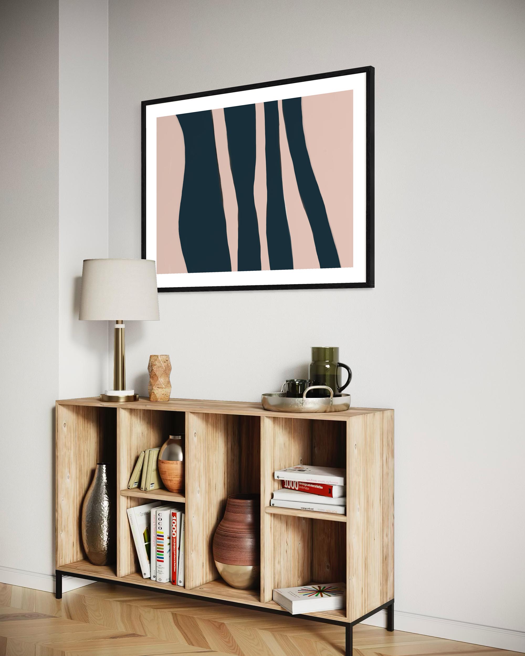 Wooden sideboard with decorative items against a wall with a framed abstract art piece.