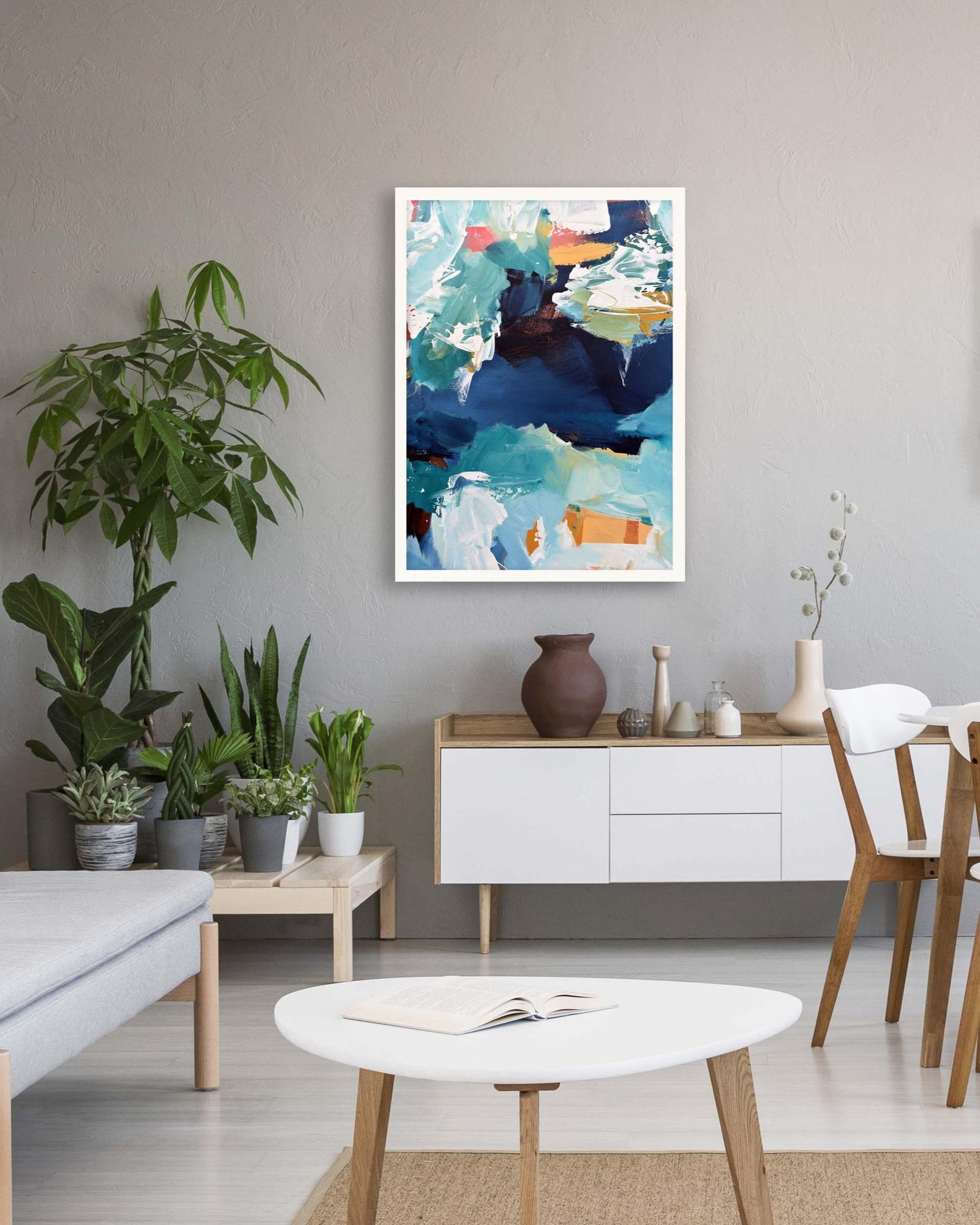 Living room with a colorful abstract painting on the wall, plants, and furniture.