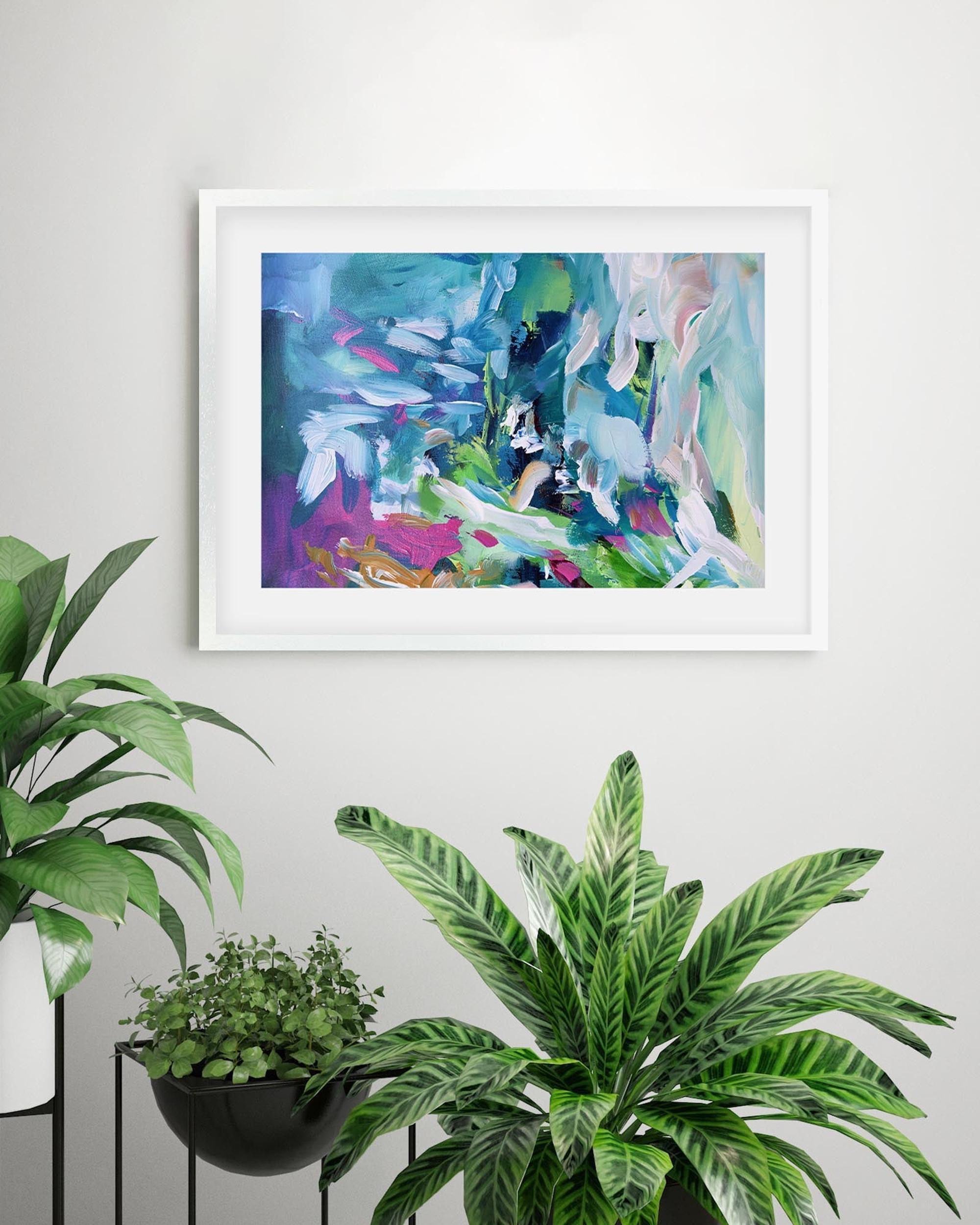 Framed abstract painting on a wall with potted plants below