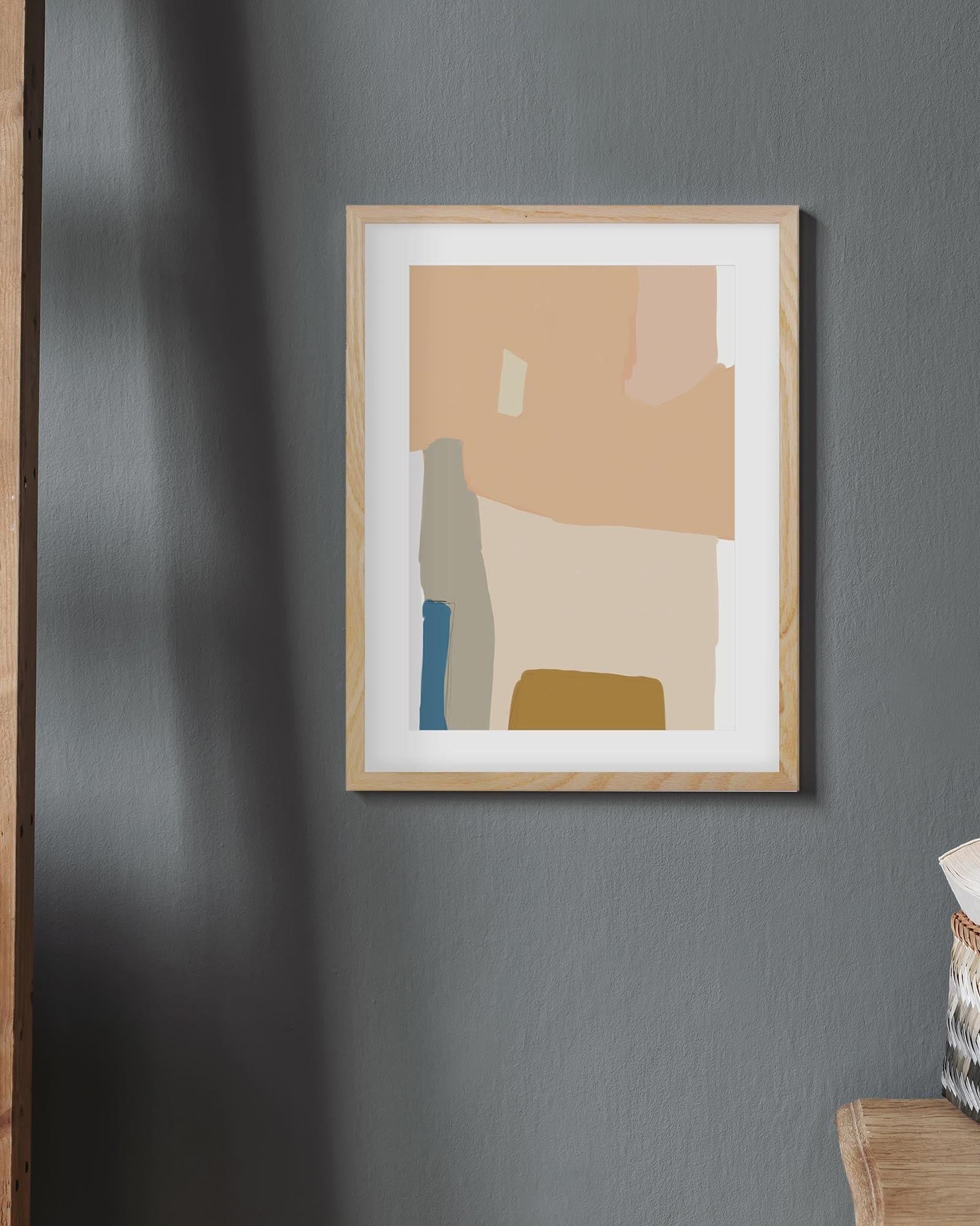 Abstract art print in a wooden frame on a gray wall