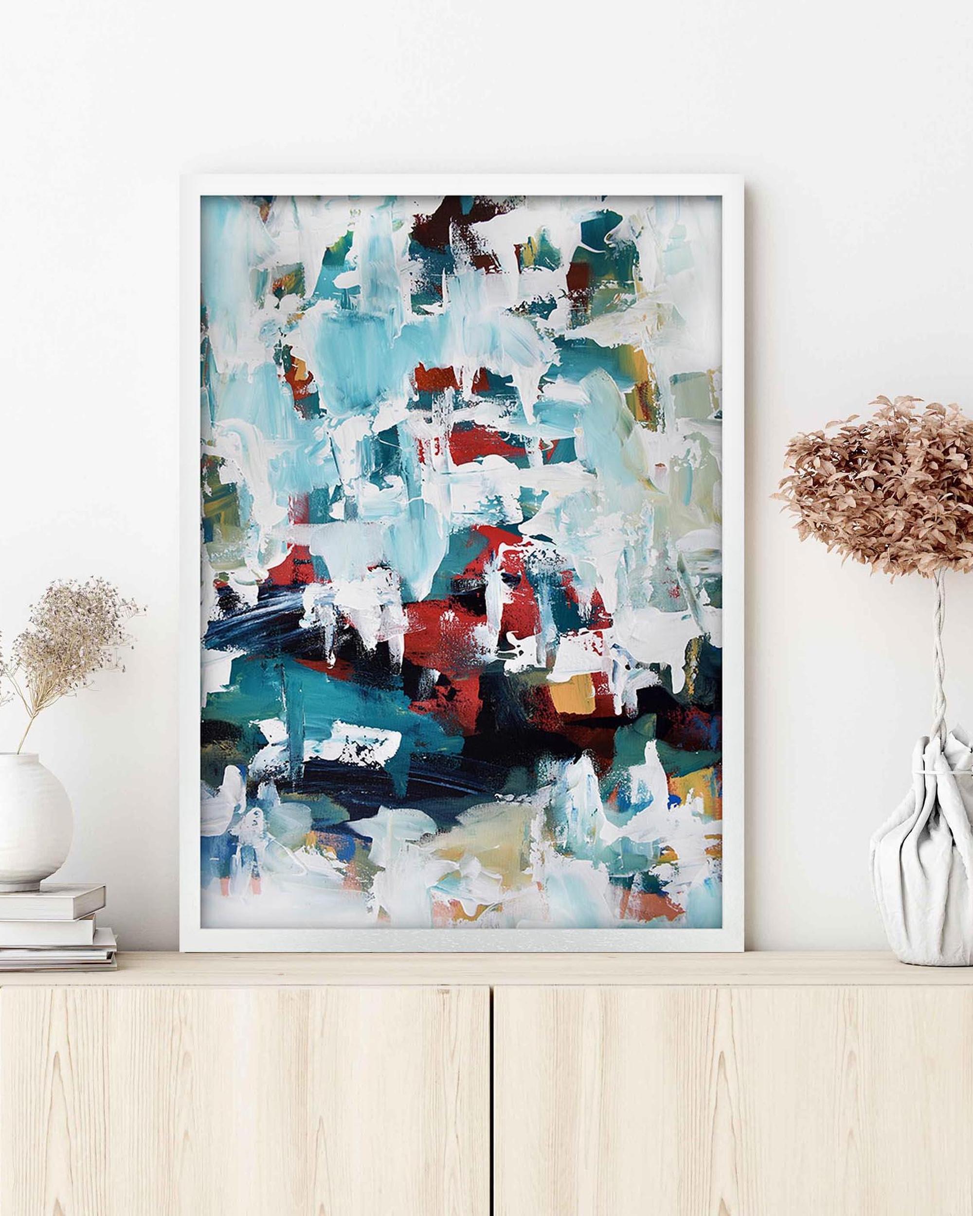 Framed abstract art print with colorful abstract design on a white wall.