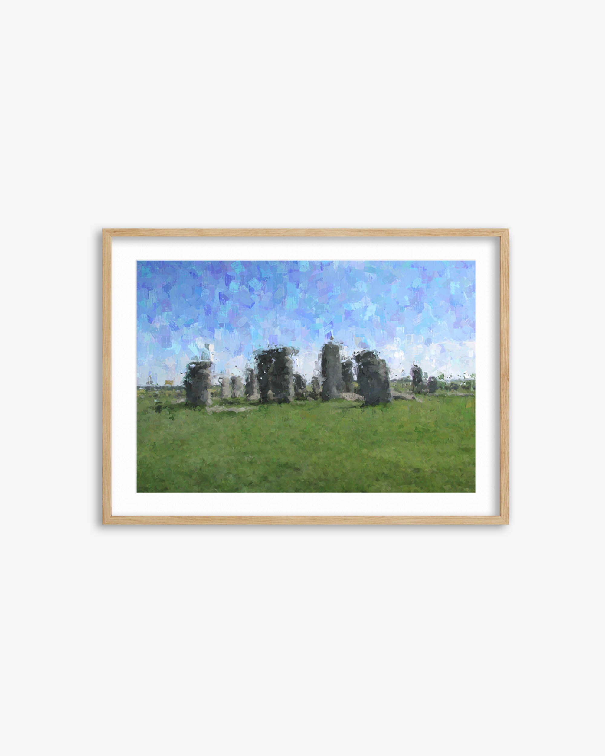 Framed artwork of Stonehenge with a blue sky and green grass.