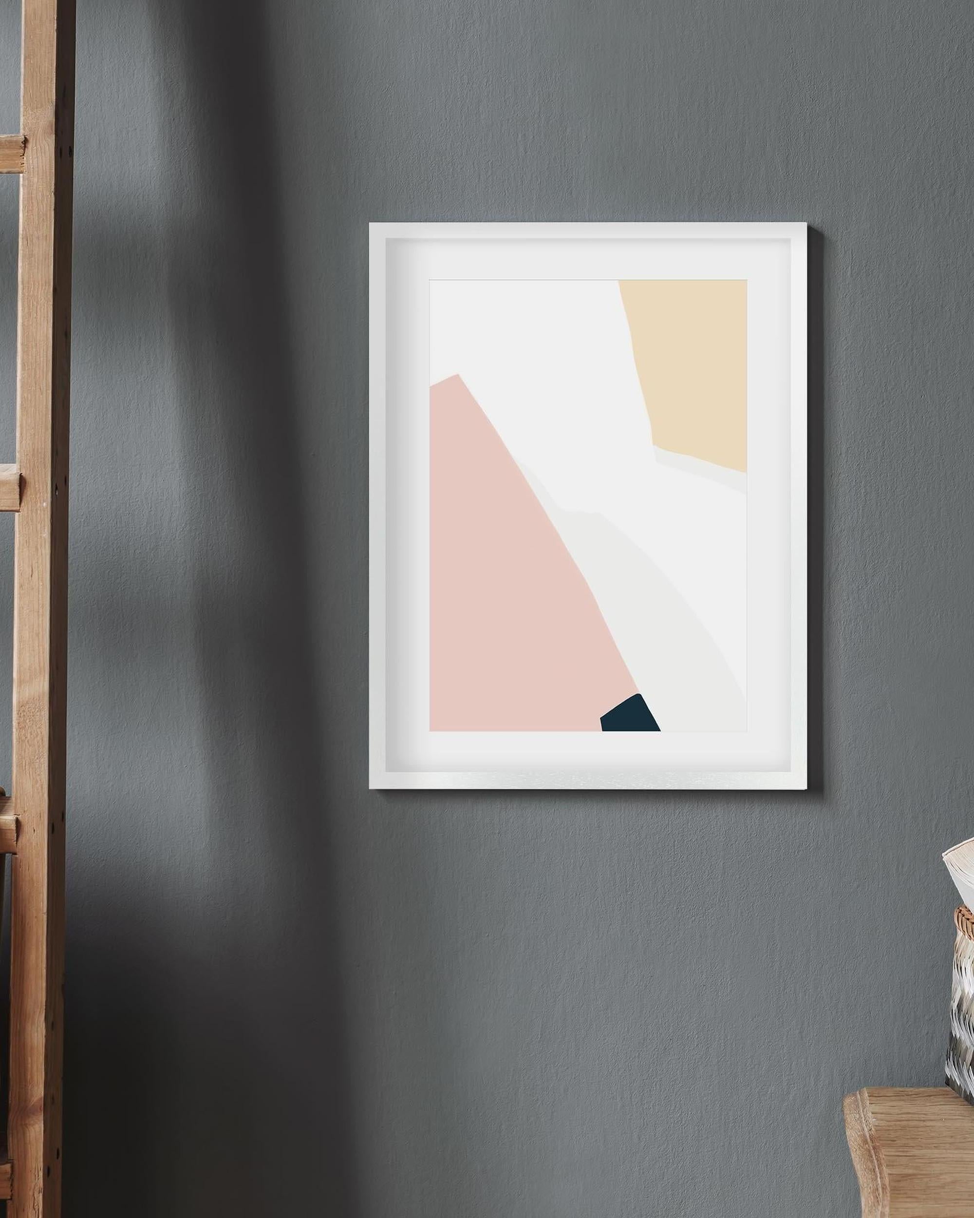 Framed abstract art print with geometric shapes on a gray wall.