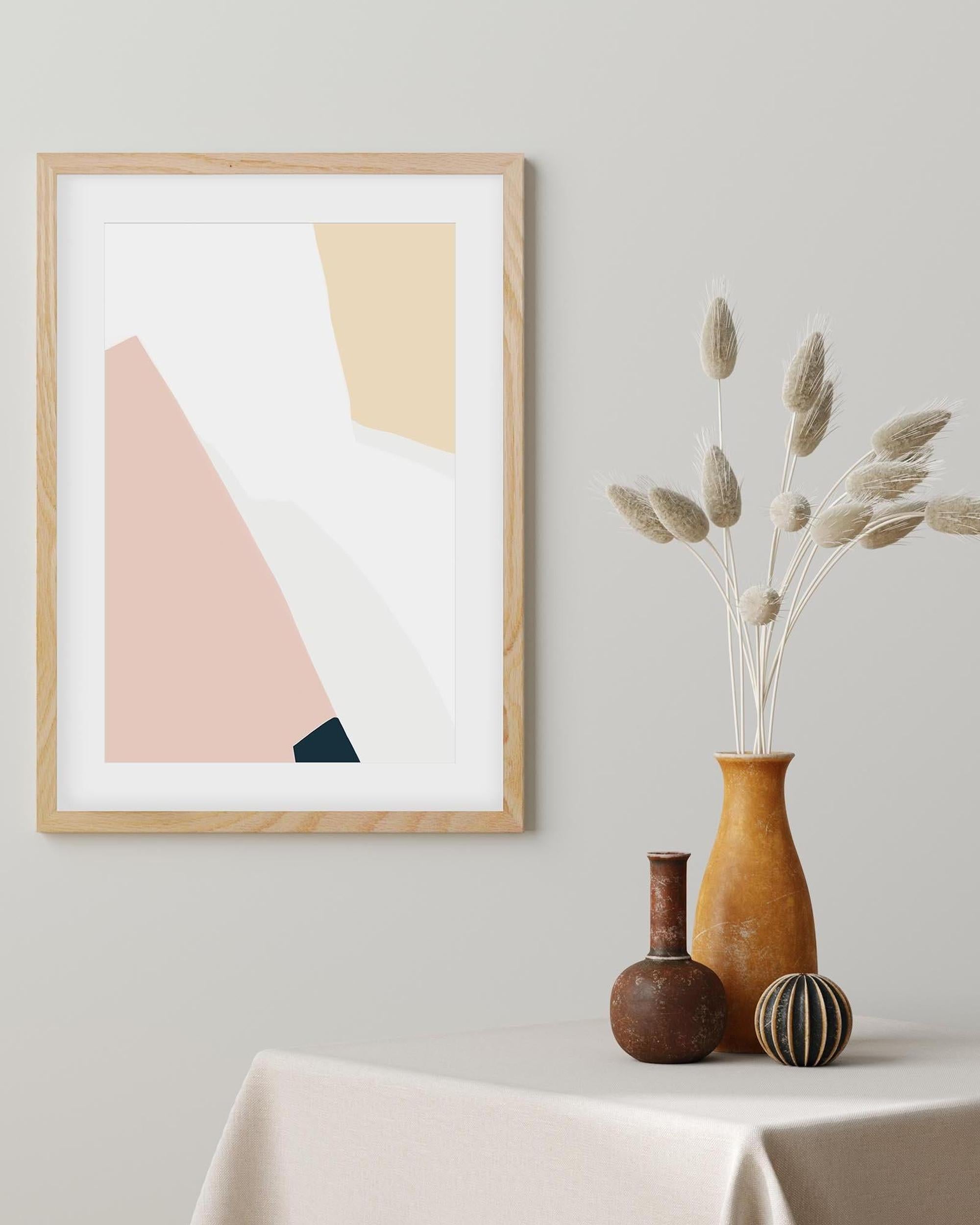 Framed abstract art piece on a wall with decorative vases on a table below.