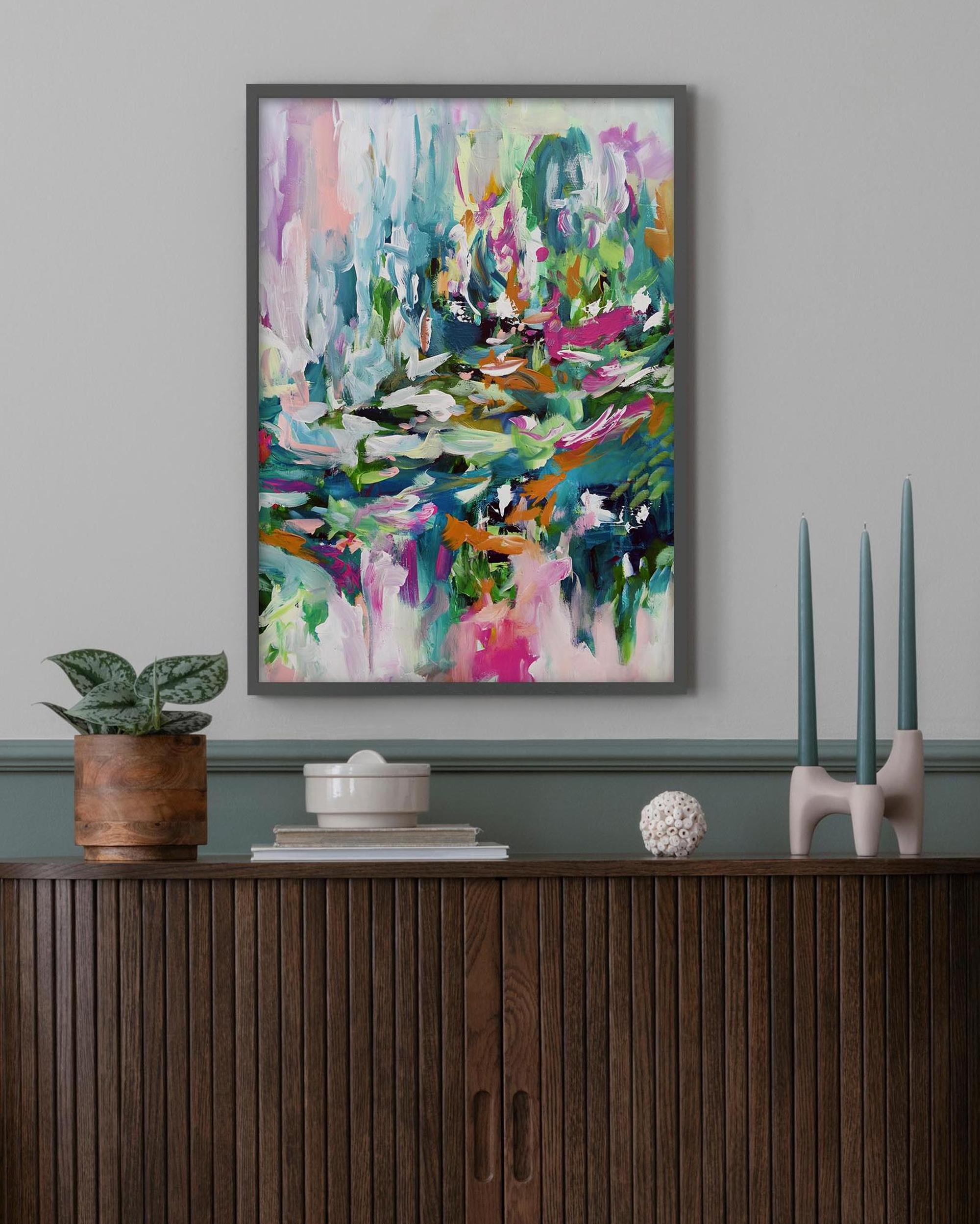 Colorful abstract painting on a wall above a wooden console table with decorative items.