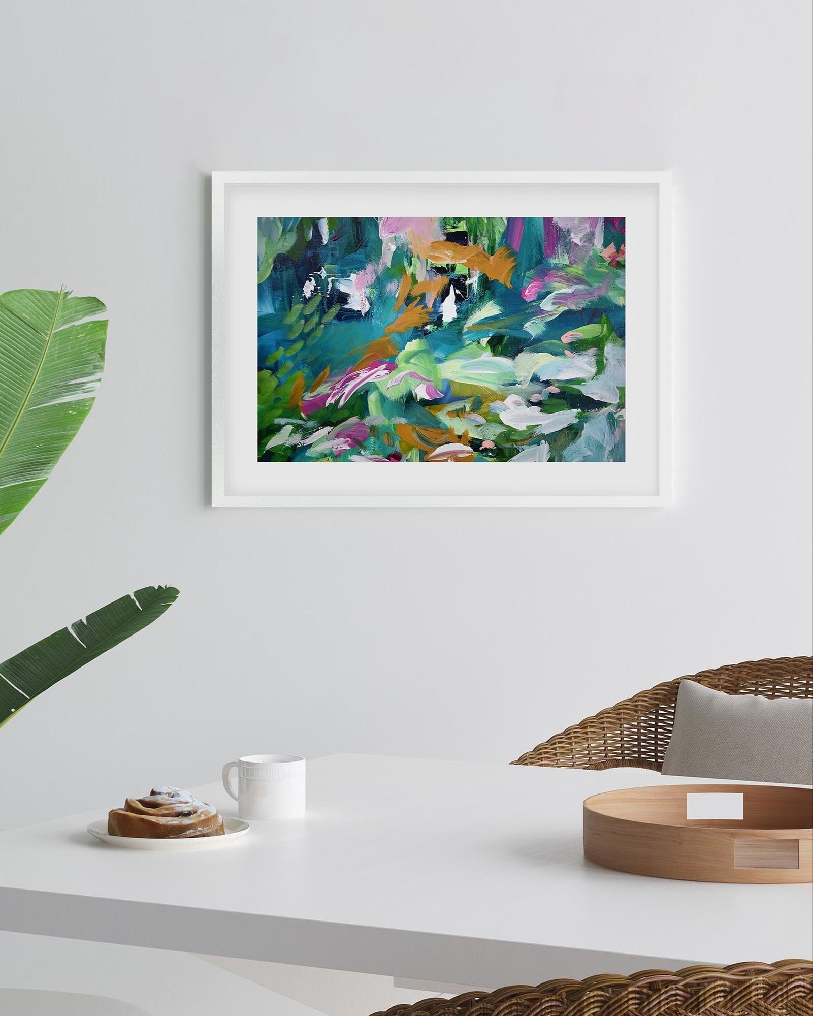 Framed abstract painting on a wall with a table and decorative items below.
