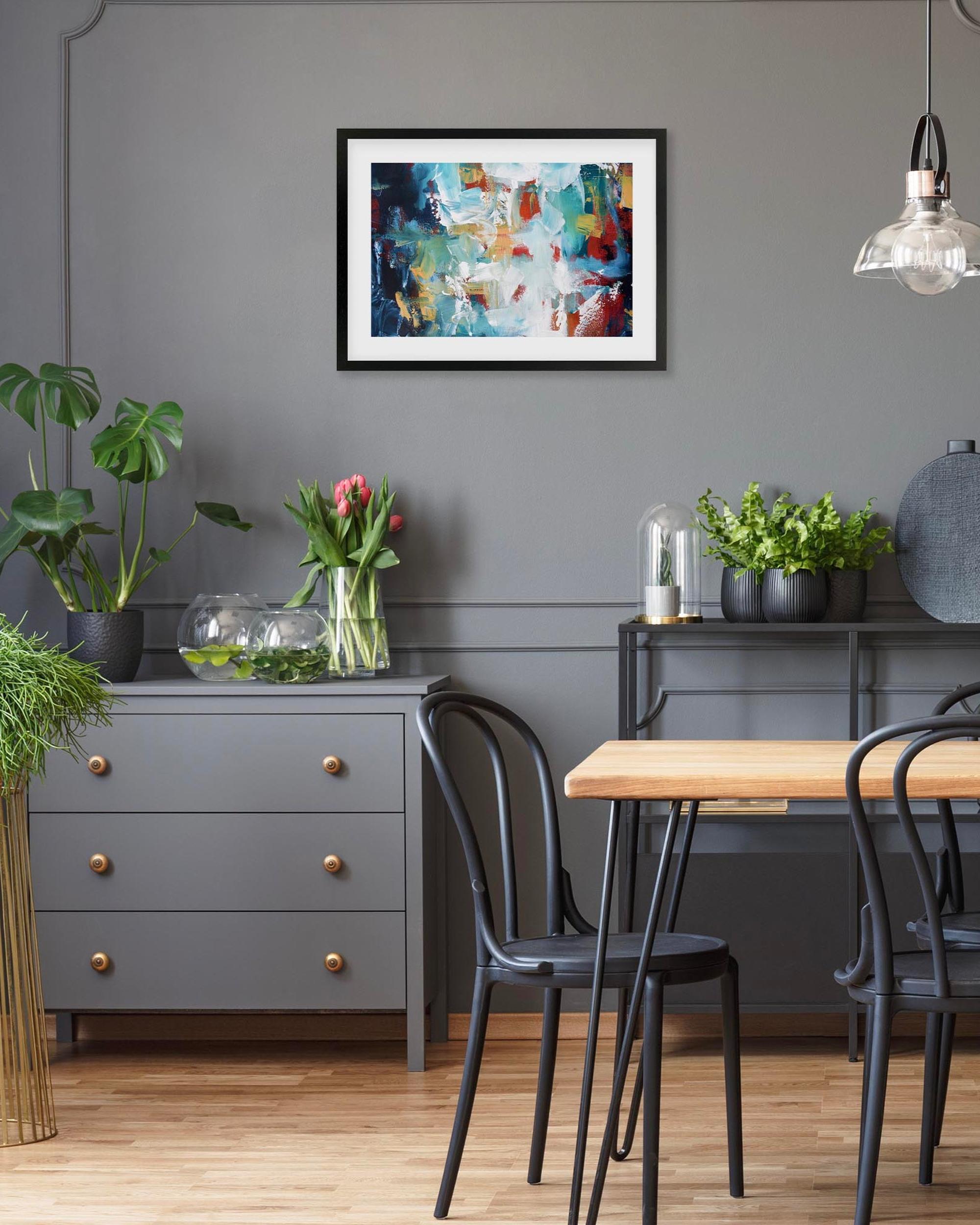 Dining room with a wooden table, black chairs, and decorative elements on a gray wall.