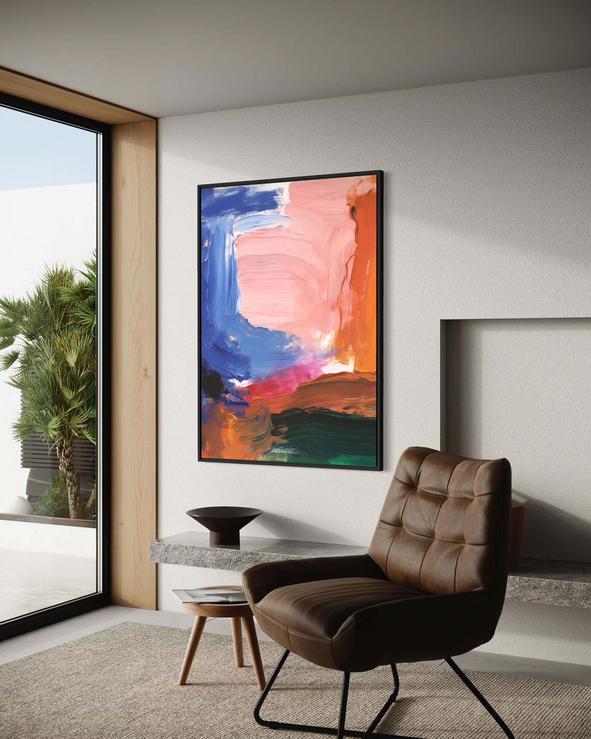 Modern interior with a brown leather chair and abstract painting on a white wall.