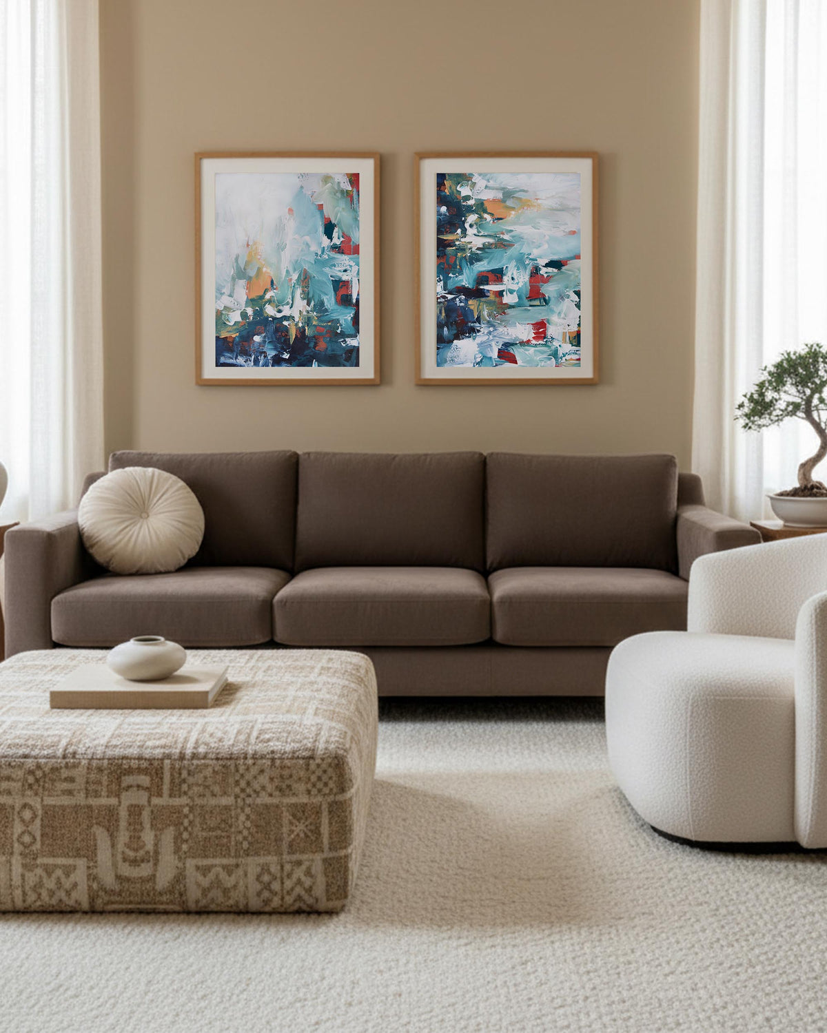 Living room with a brown sectional sofa, patterned ottoman, and abstract paintings on the wall.
