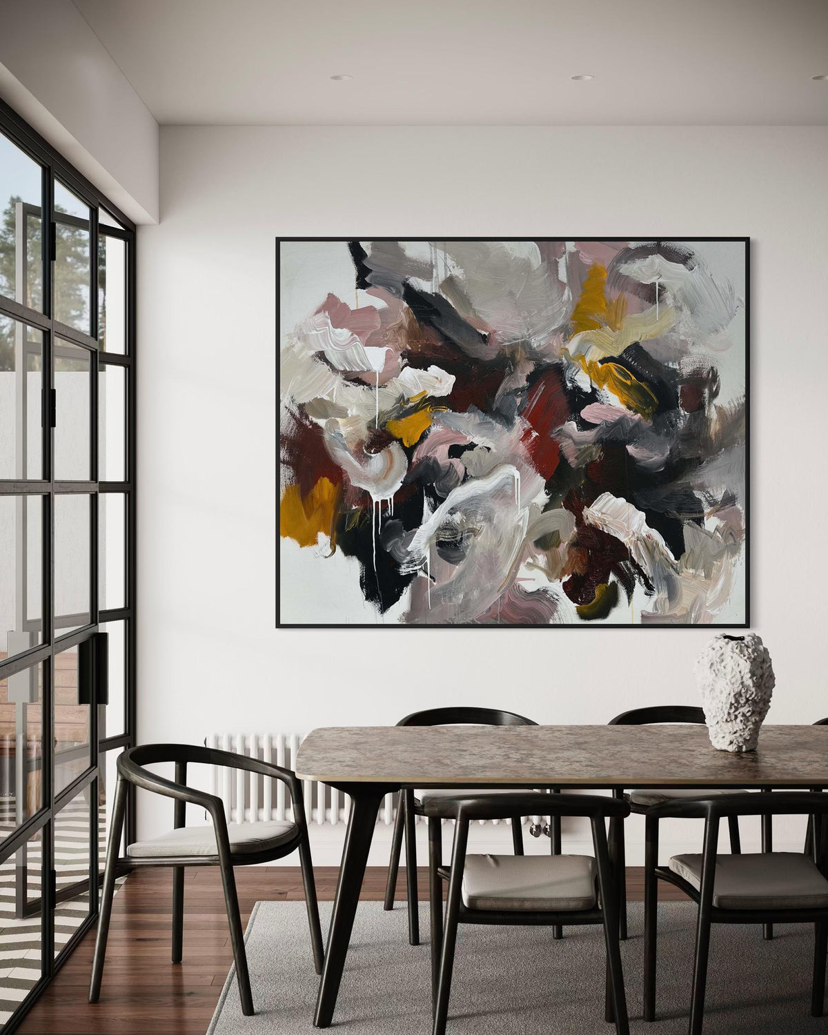 Dining room with a large abstract painting on the wall above a wooden table.