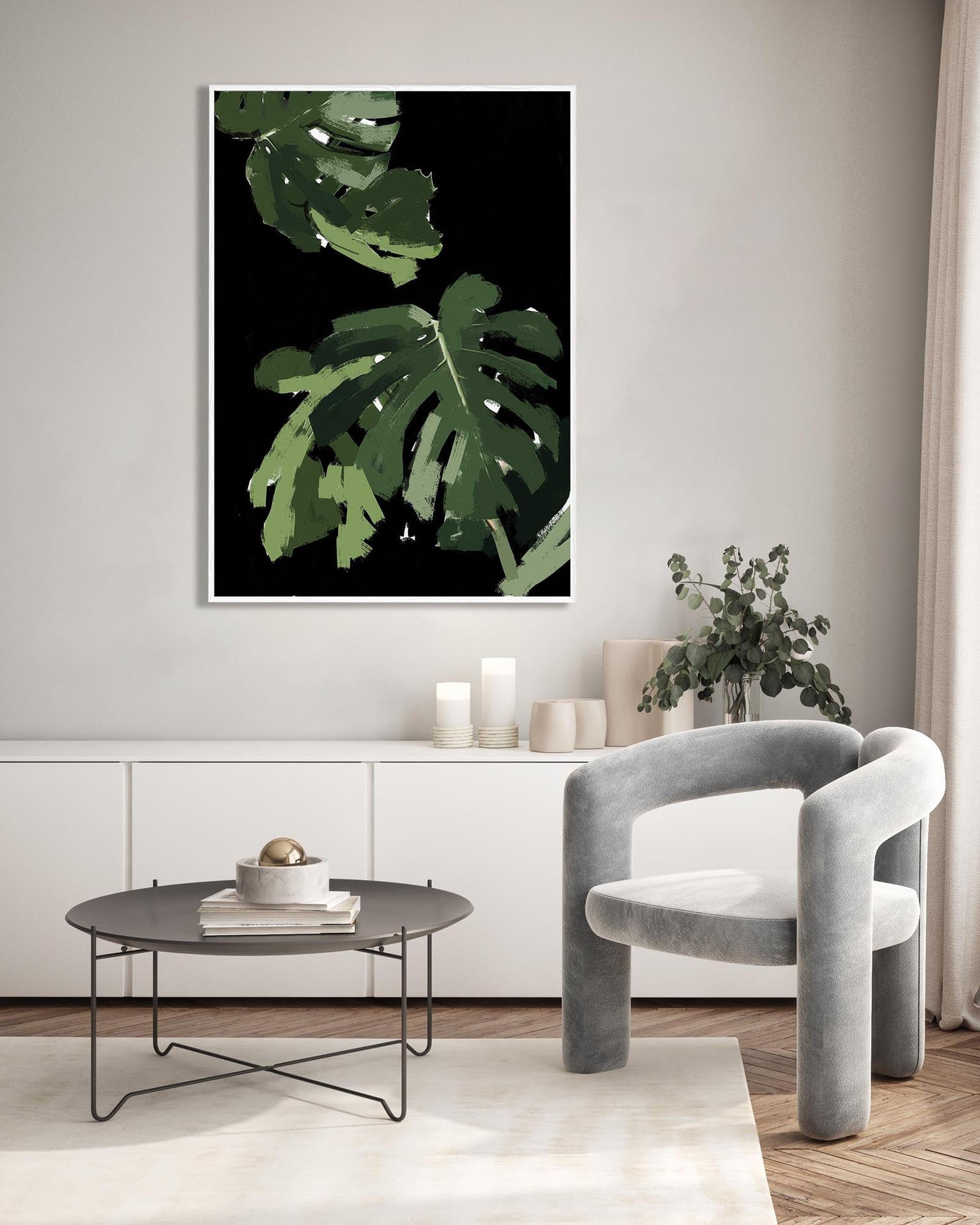 Modern living room with a gray armchair, round coffee table, and a large green leaf print on the wall.