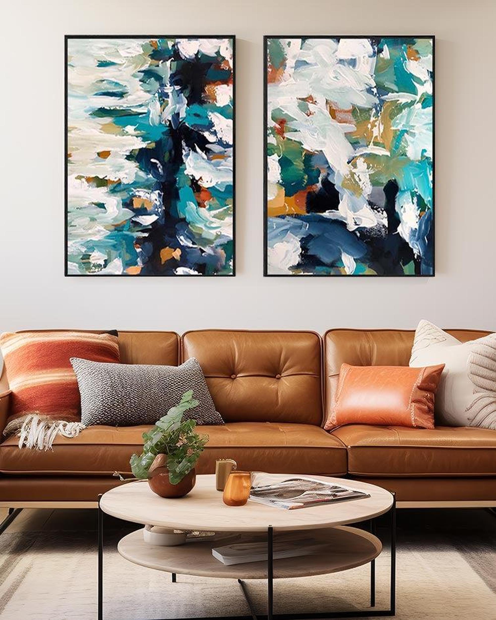 Two abstract paintings above a brown leather sofa in a living room.