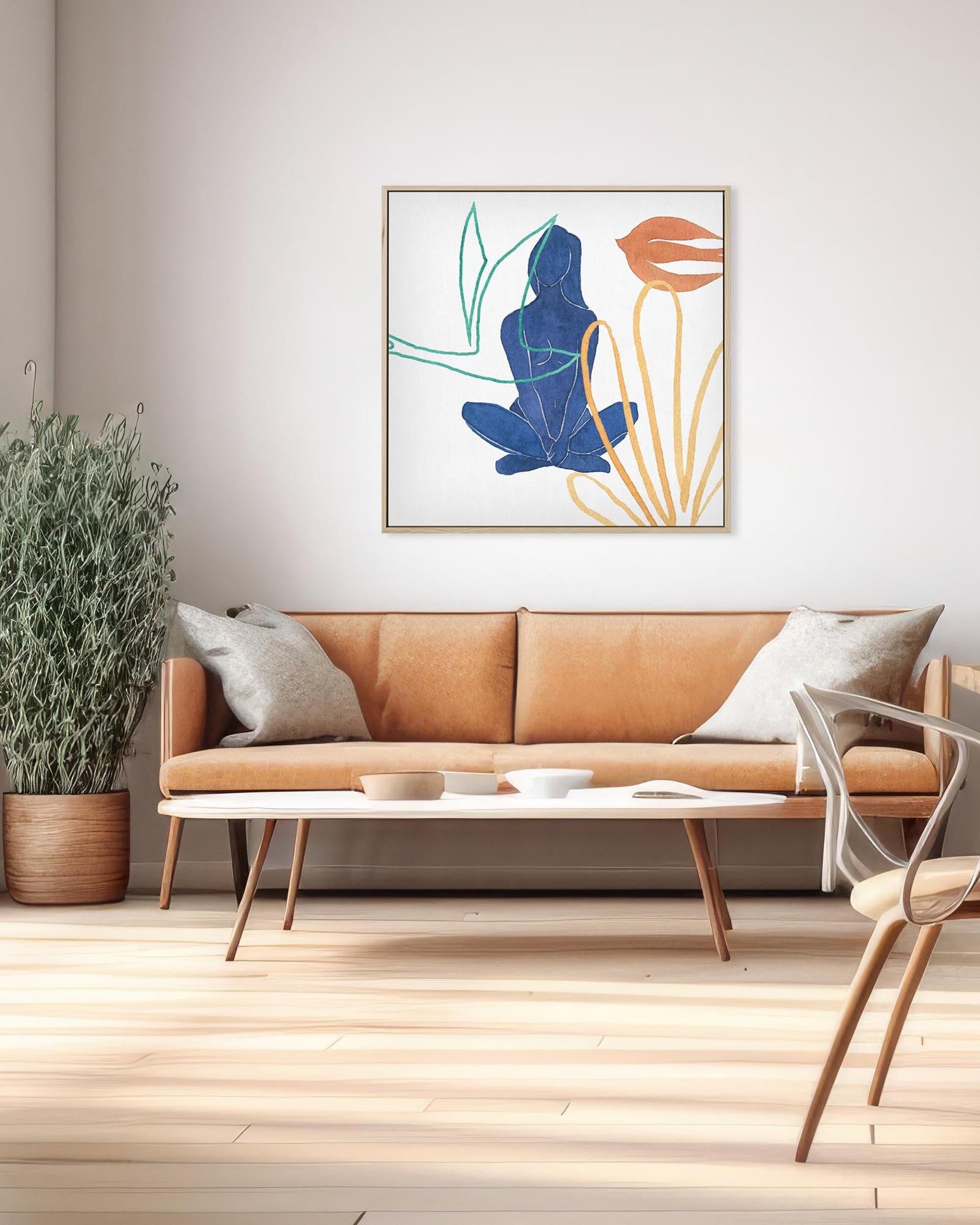 Modern living room with a tan sofa, plant, and abstract art on the wall.