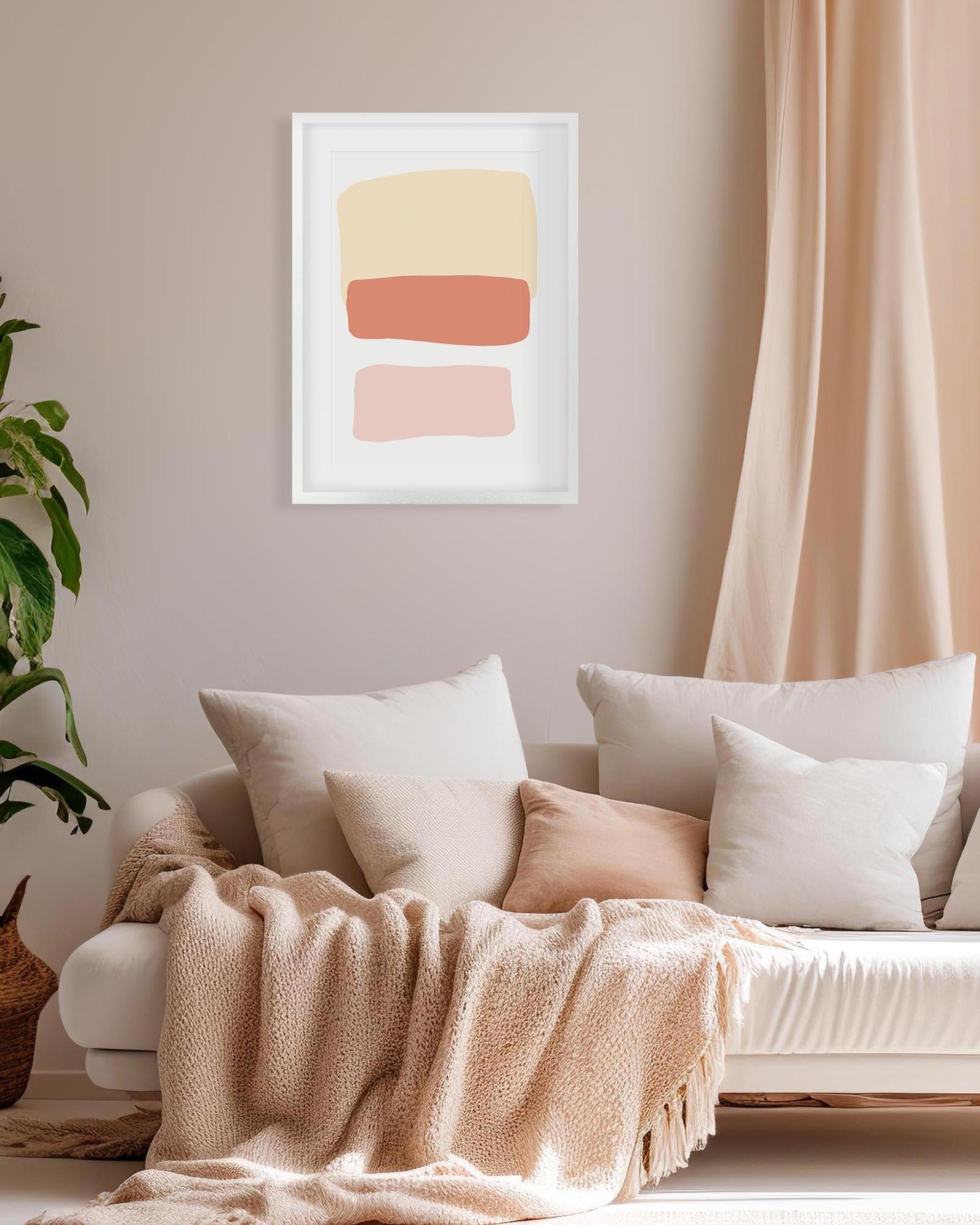 Living room with a beige sofa, white pillows, a blanket, and a abstract art print on the wall.
