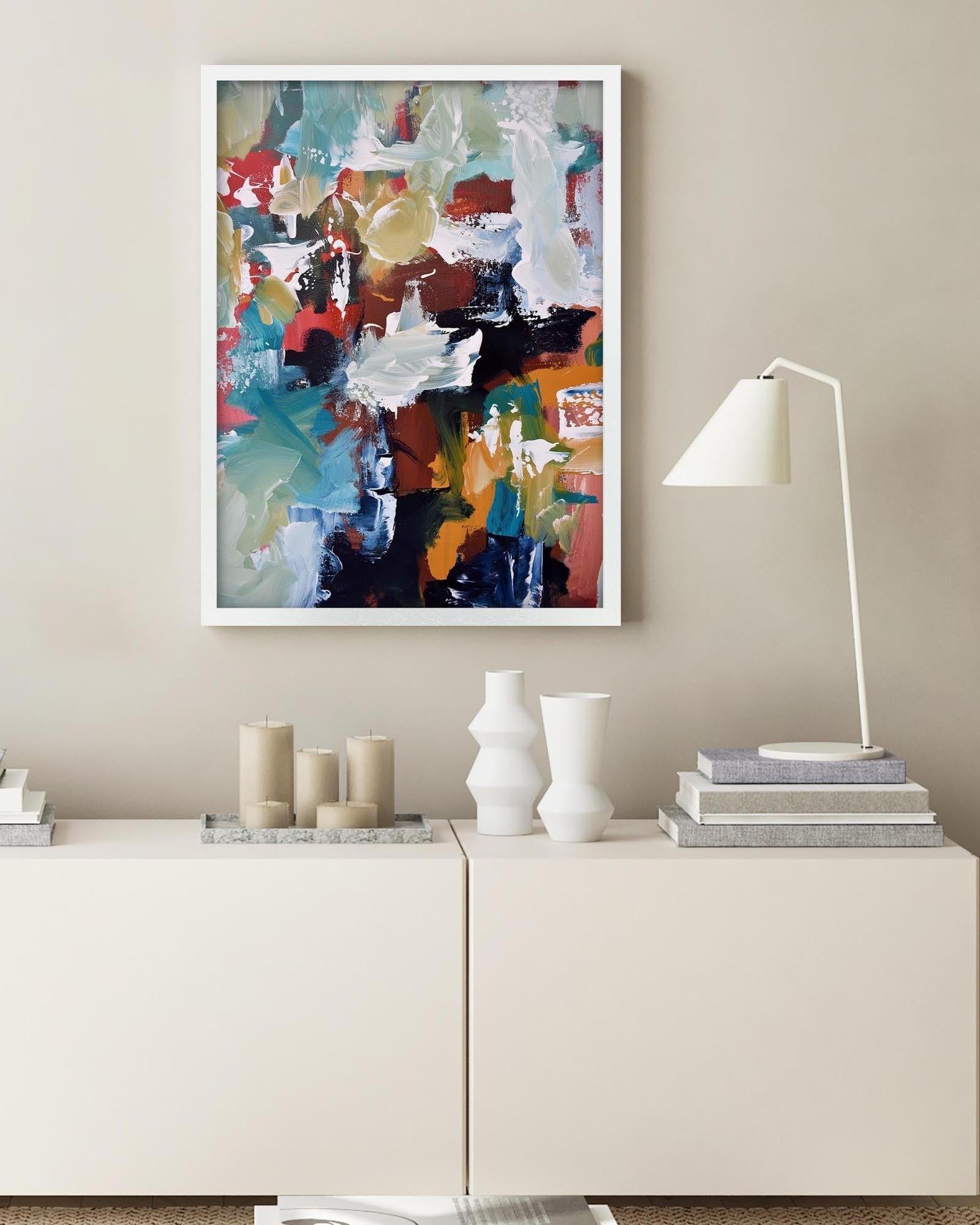 Modern interior with abstract art, candles, and books on a white cabinet.