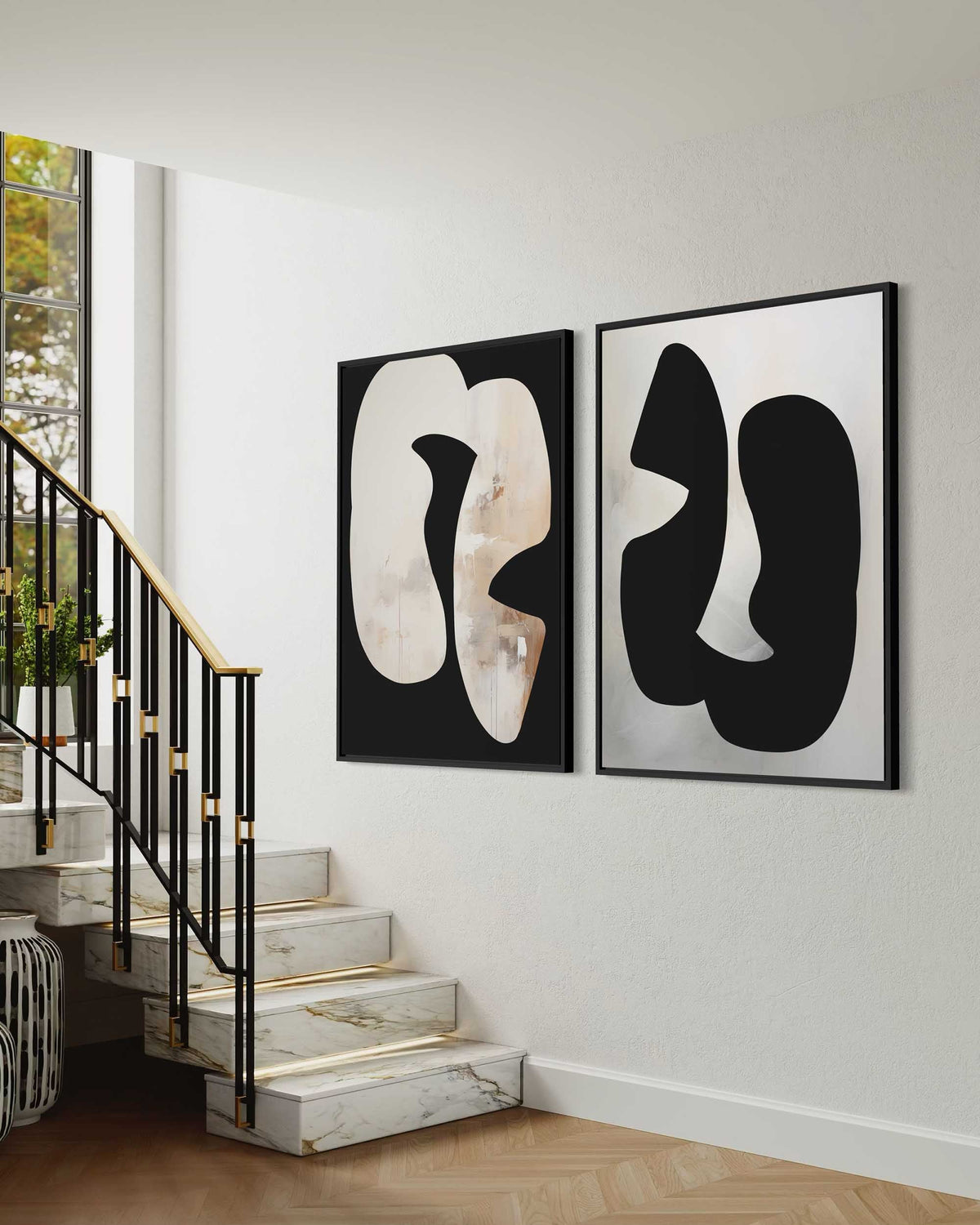 Abstract art pieces on a wall above a staircase