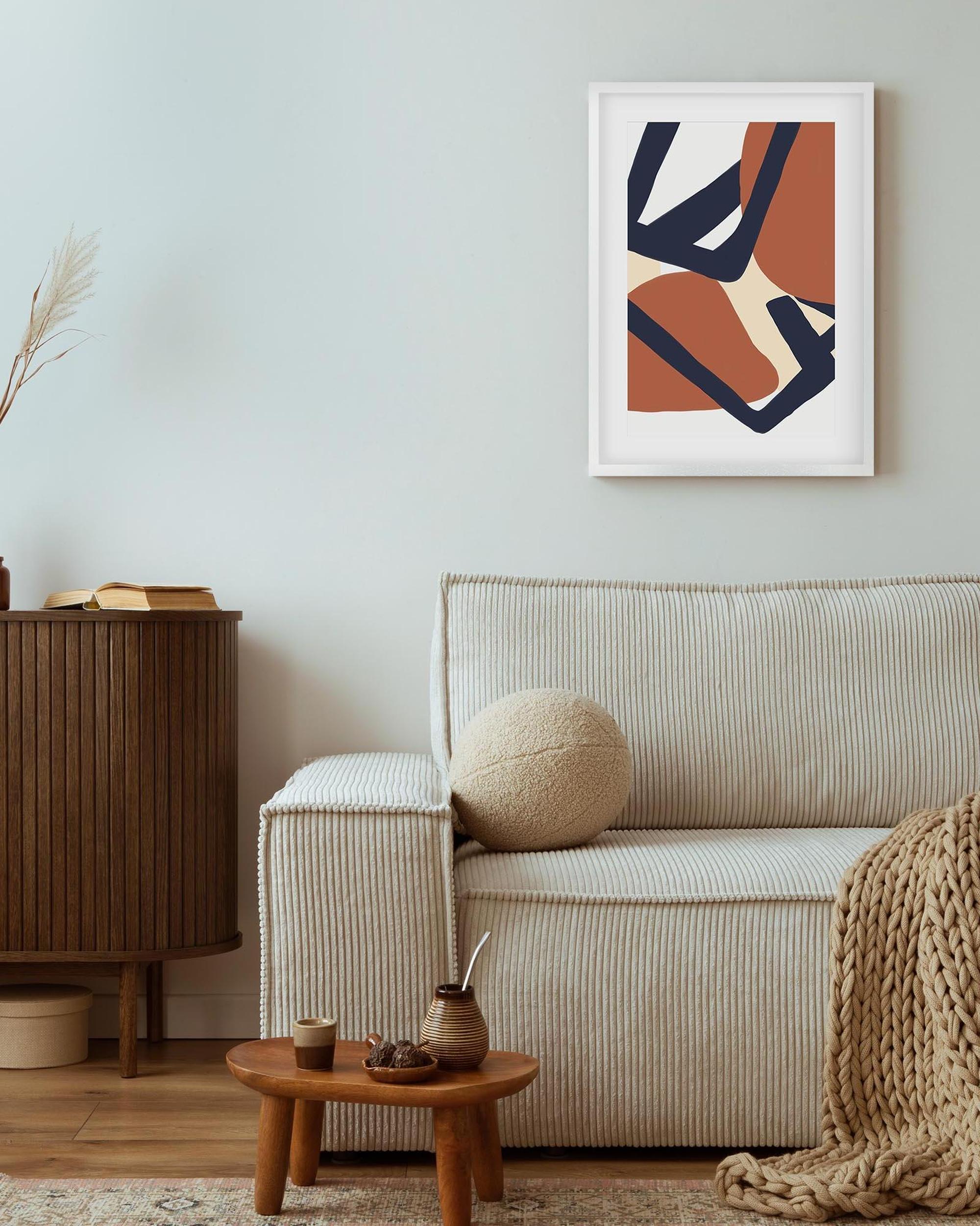 Living room with a beige sofa, wooden side table, and abstract art on the wall.