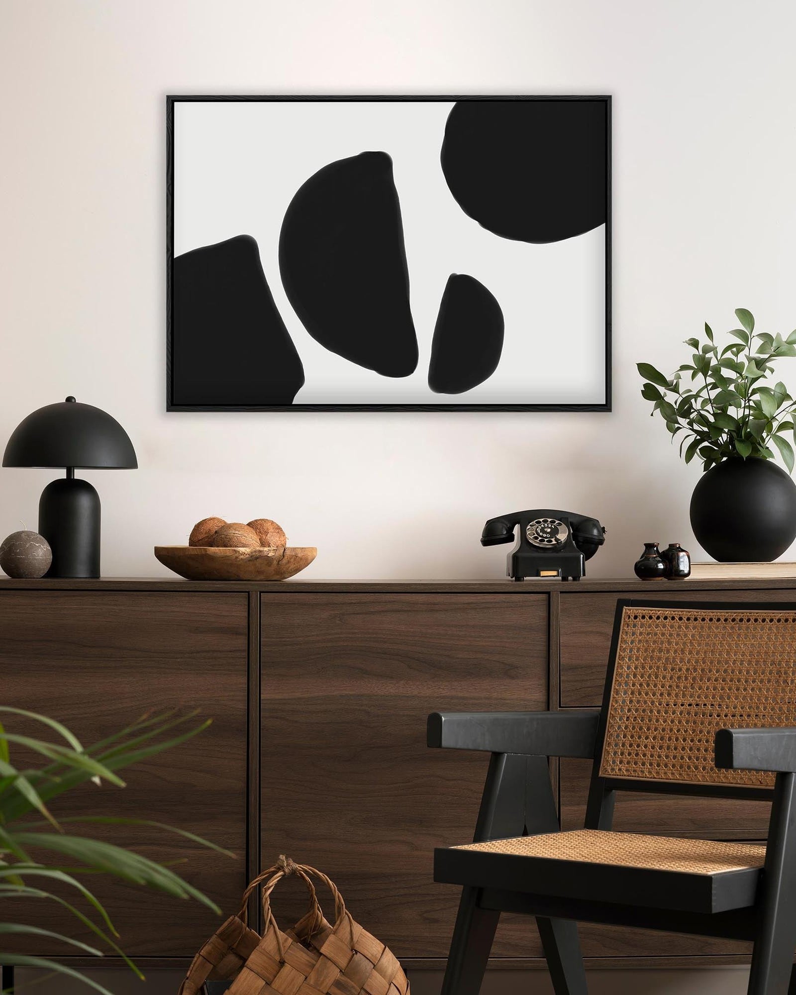 Modern interior with a wooden cabinet, abstract art, and decorative items.