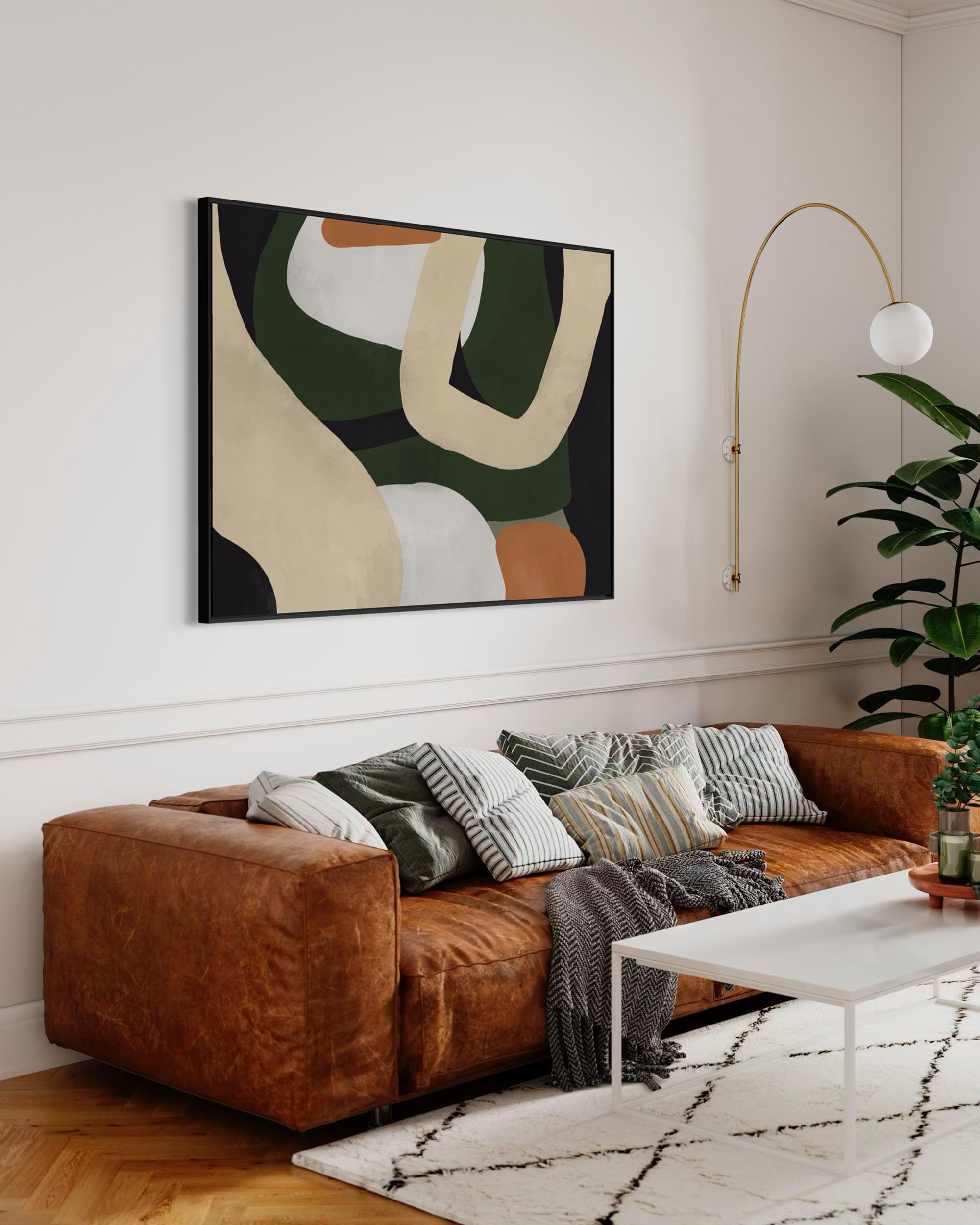Living room with a brown sofa, abstract art, and a plant.
