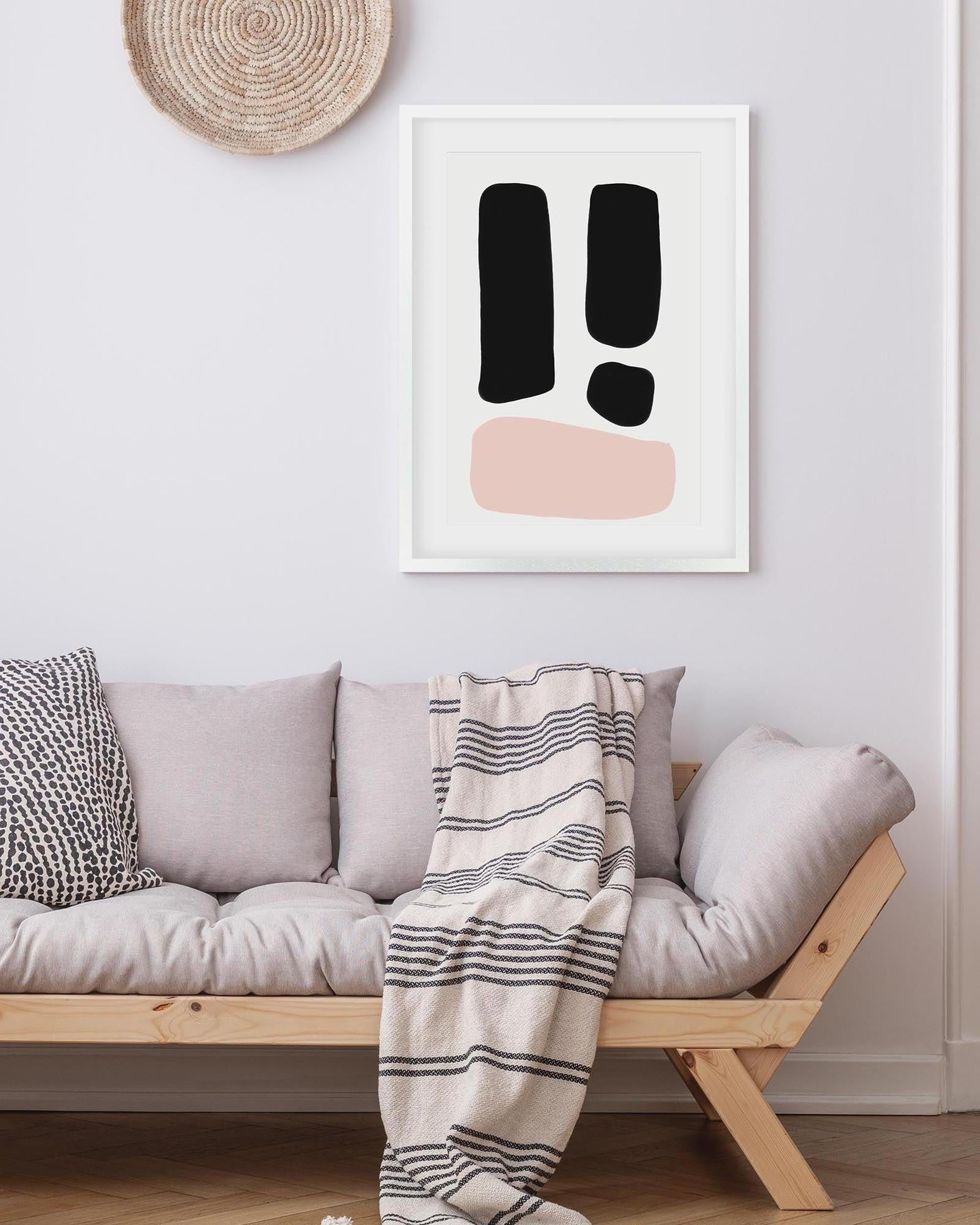 Modern living room with a sofa, striped blanket, and abstract art on the wall.