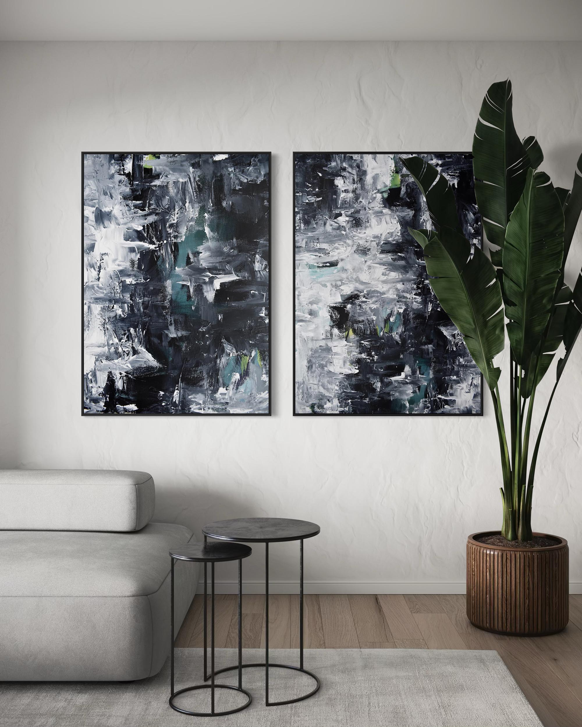 Two abstract paintings on a wall above a sofa with a plant and side tables in the foreground.