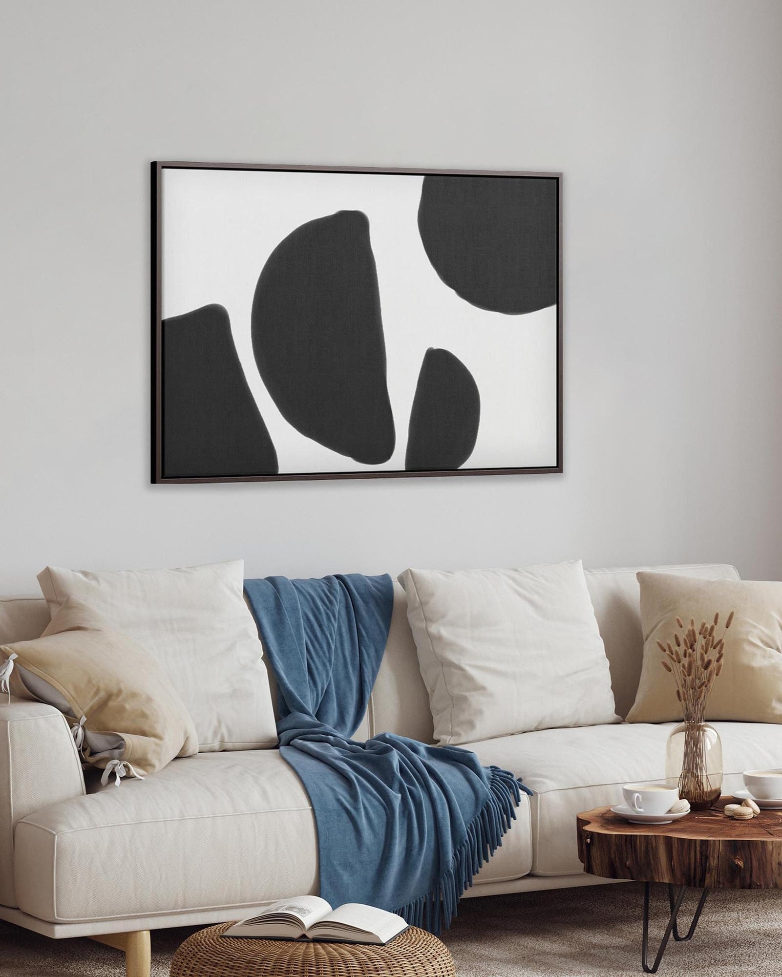 Modern living room with a white sofa, abstract art, and decorative items.