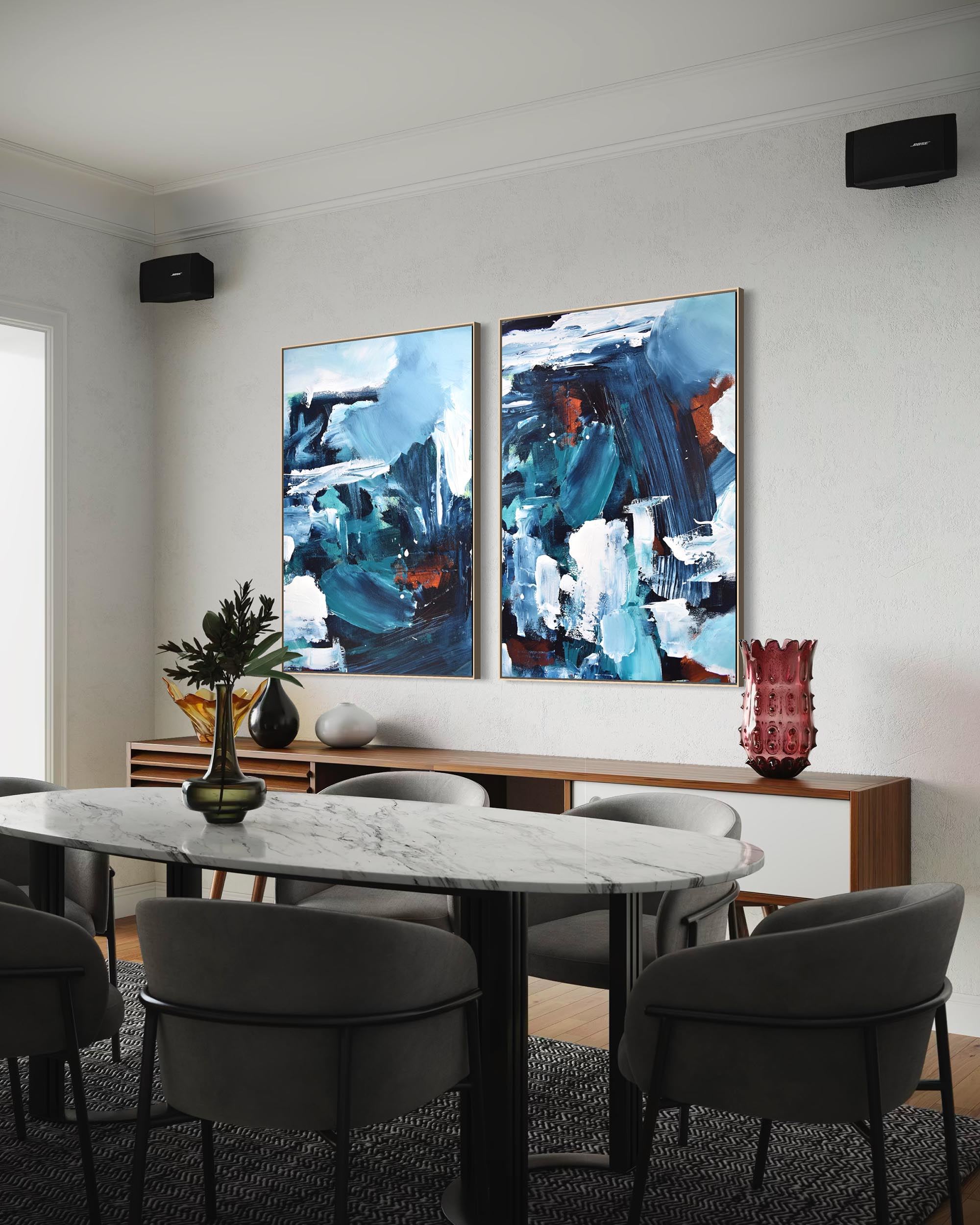 Dining room with abstract paintings on the wall above a table and chairs.