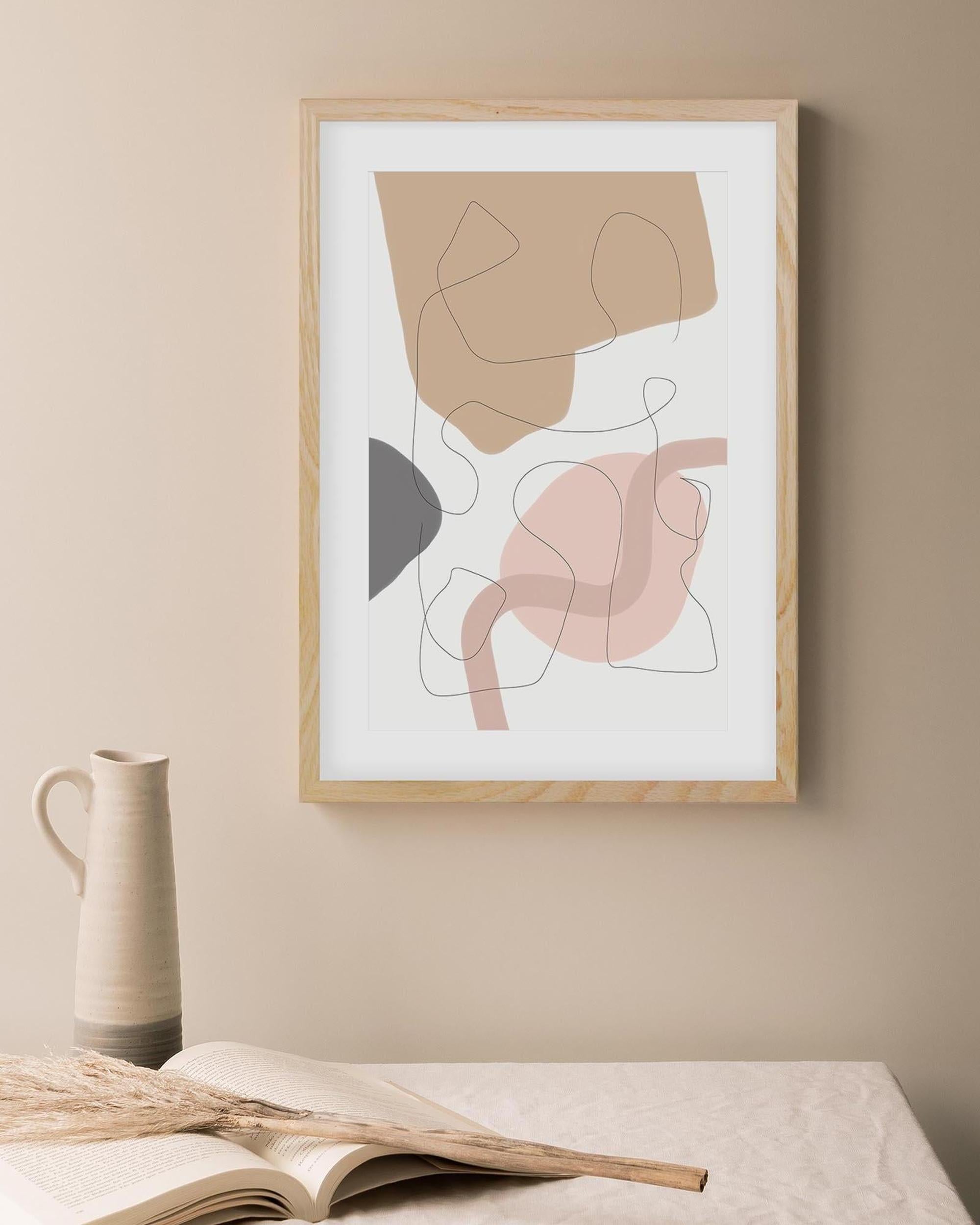 Abstract art print in a wooden frame on a beige wall with a vase and book below.
