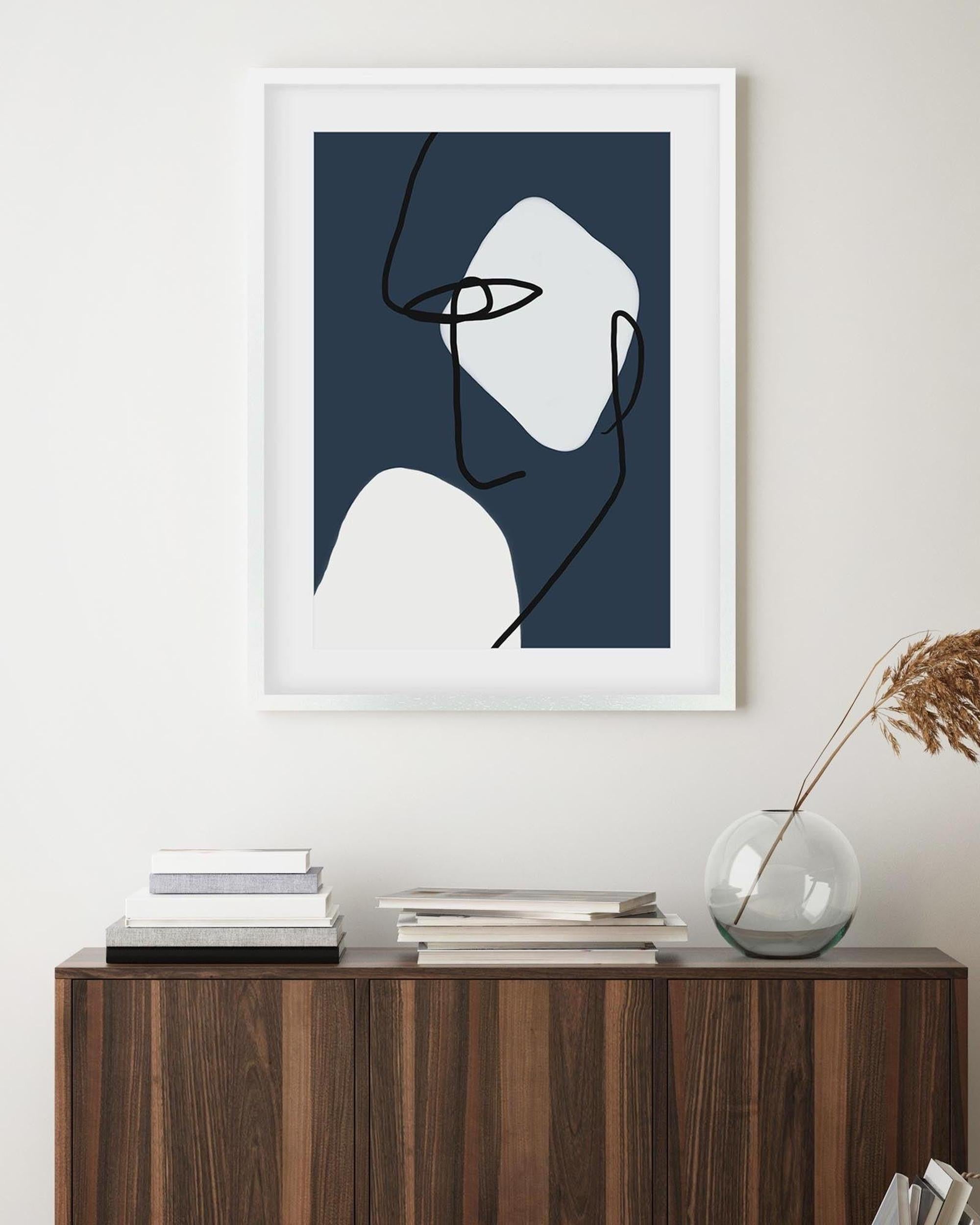 Framed abstract art on a wall above a wooden console table.