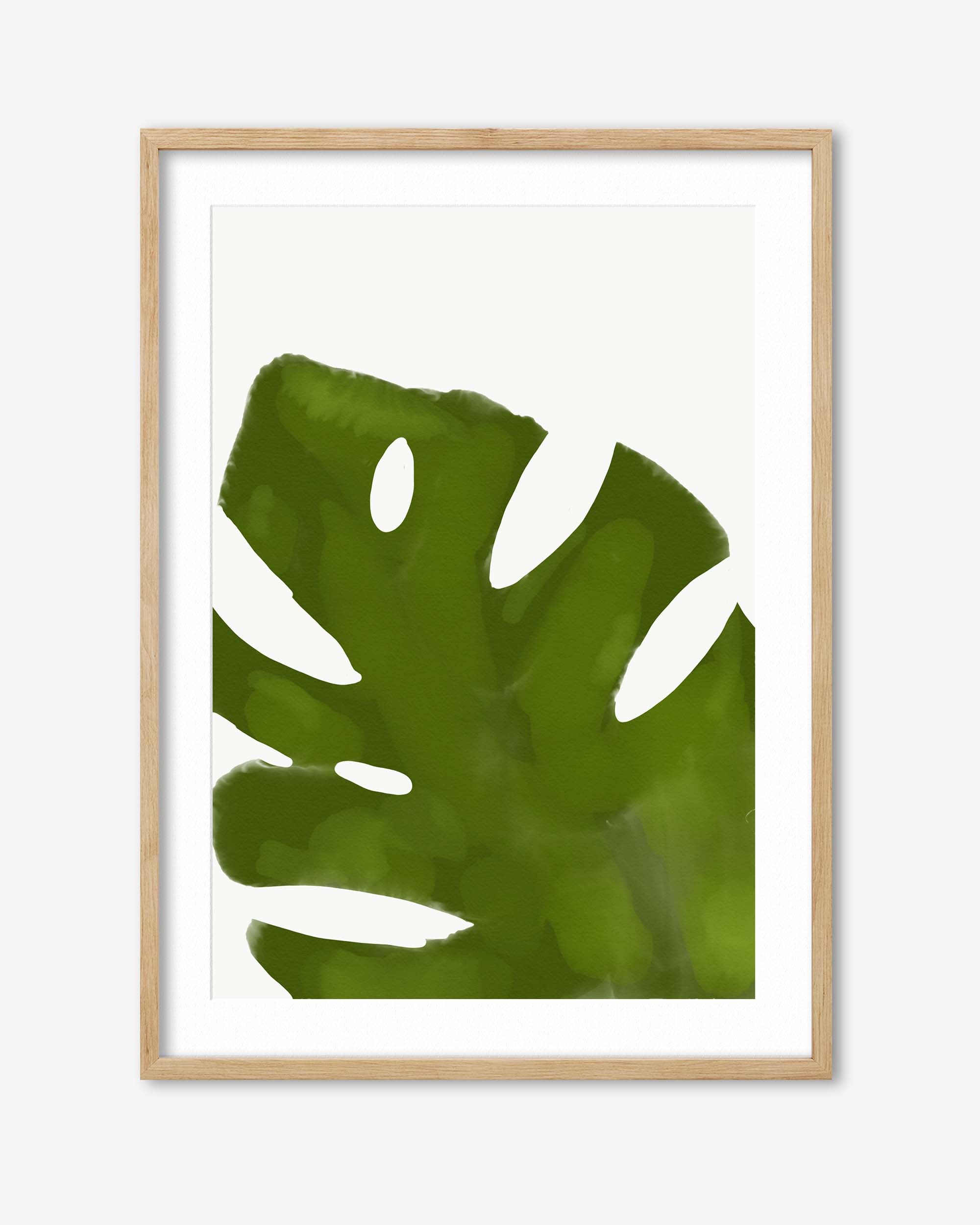 Framed artwork of a green leaf with a wooden frame on a white background