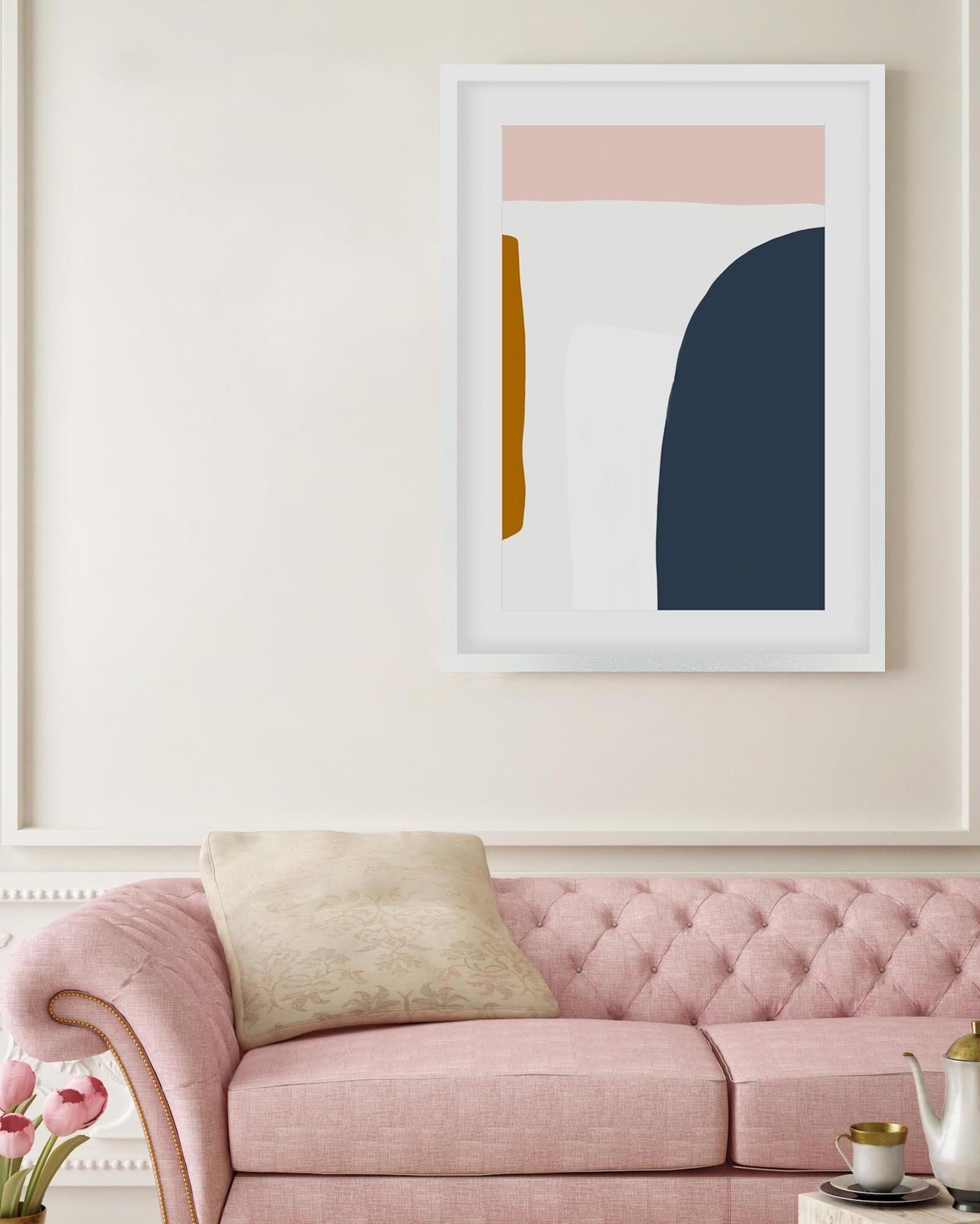 Framed abstract art piece on a wall above a pink sofa with a beige pillow.