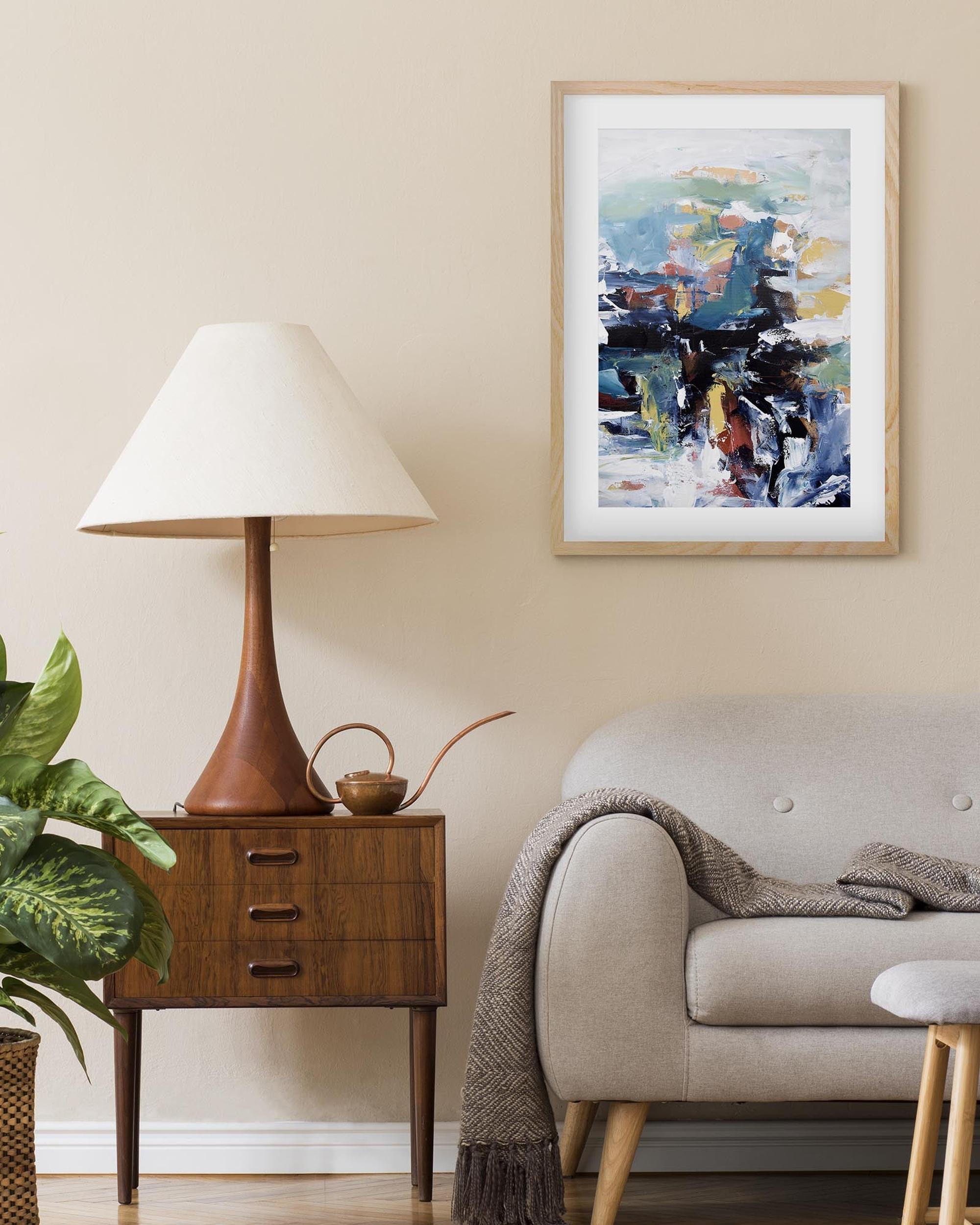 Living room with a lamp, side table, sofa, and abstract painting on the wall.