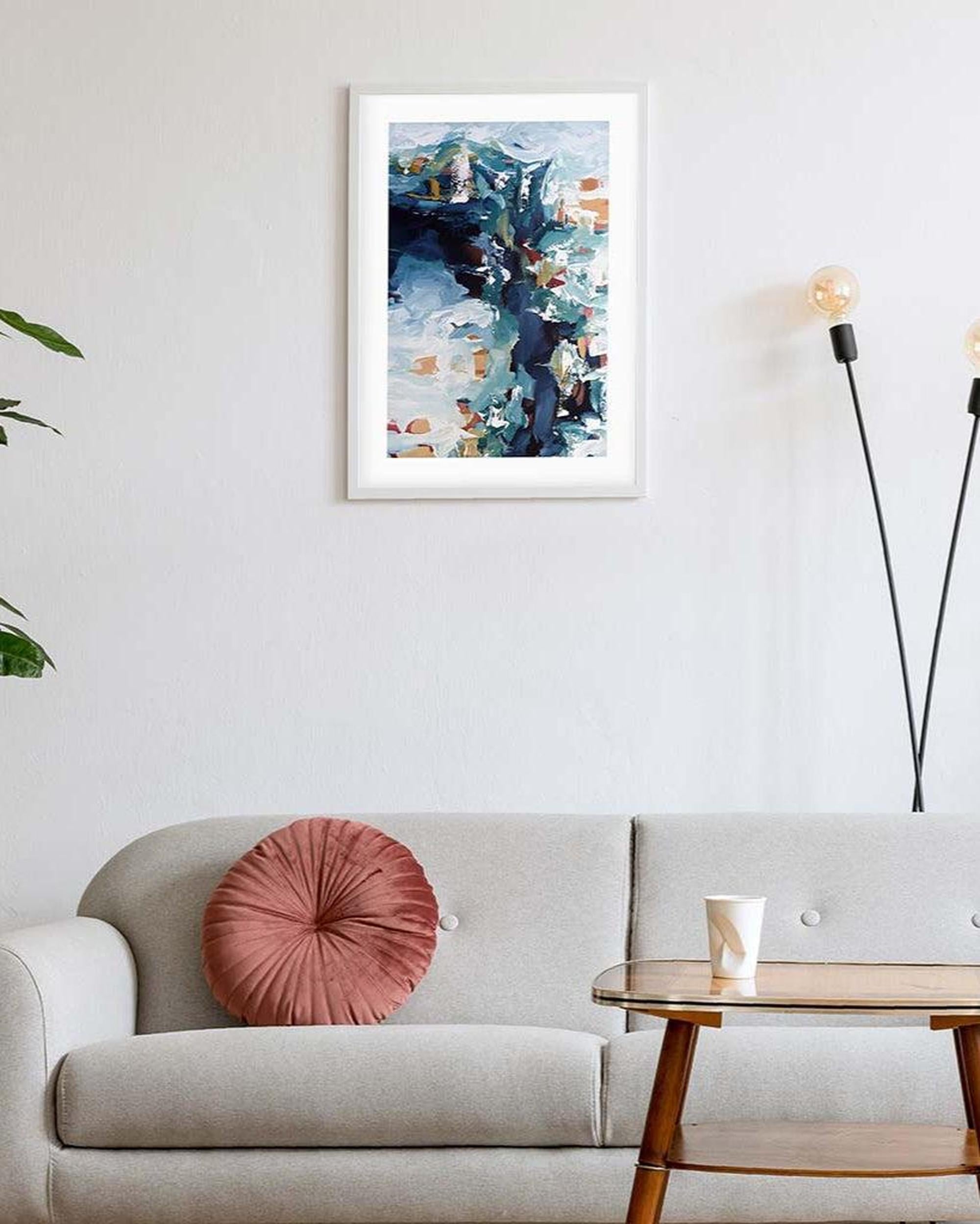 Framed abstract art above a sofa in a living room setting