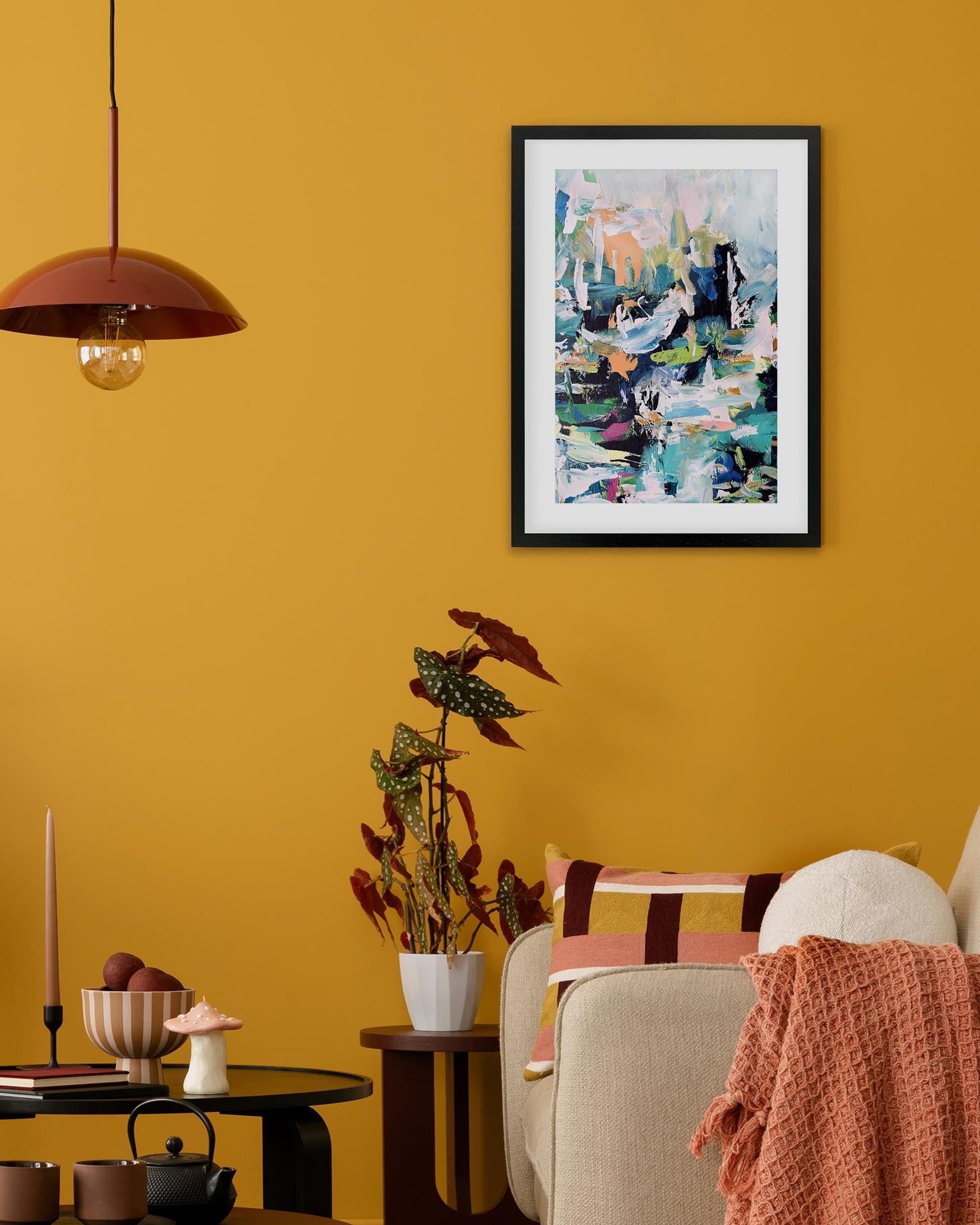 Living room with yellow walls, a framed abstract painting, and decorative items.