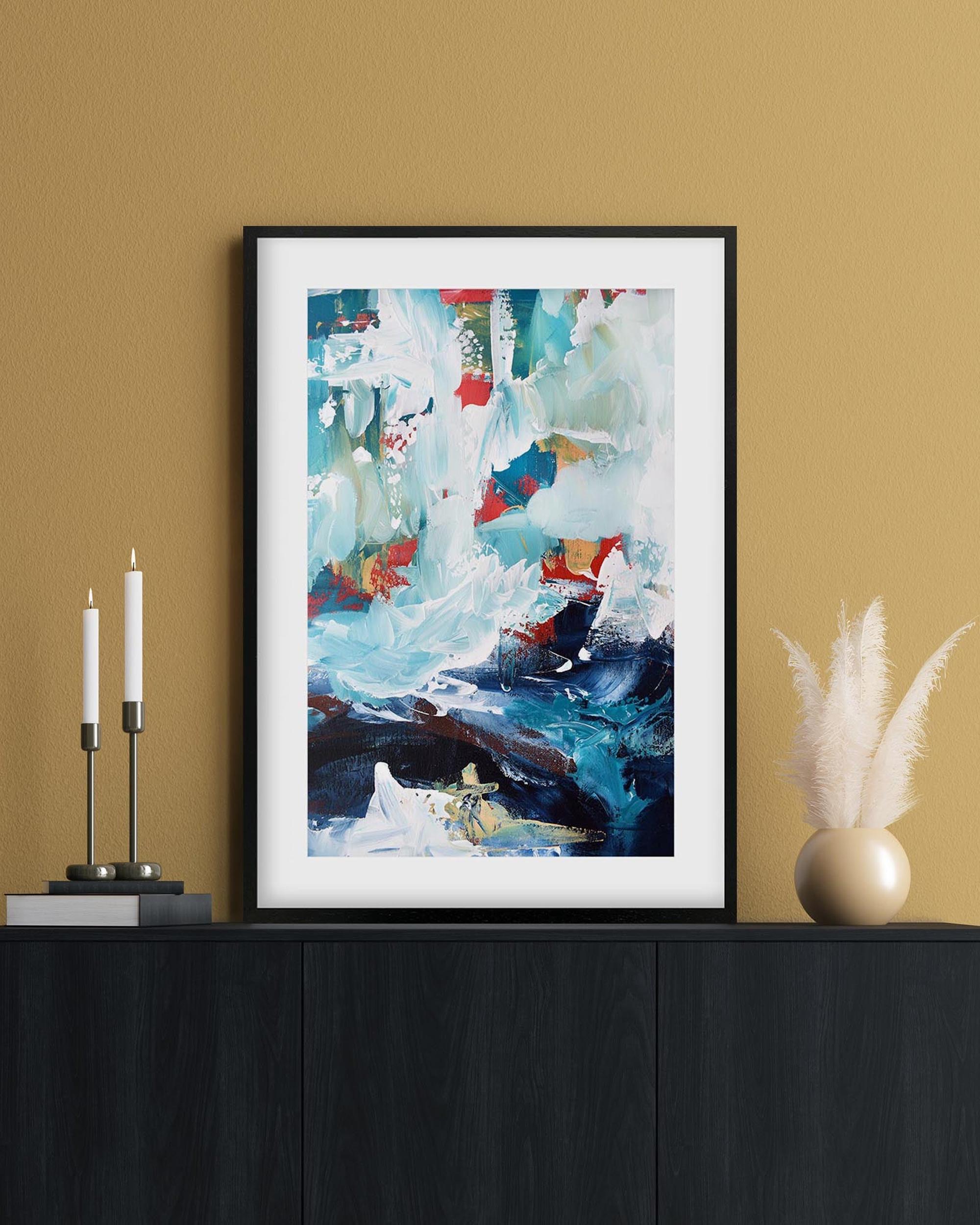 Framed abstract painting on a wall with decorative items below.