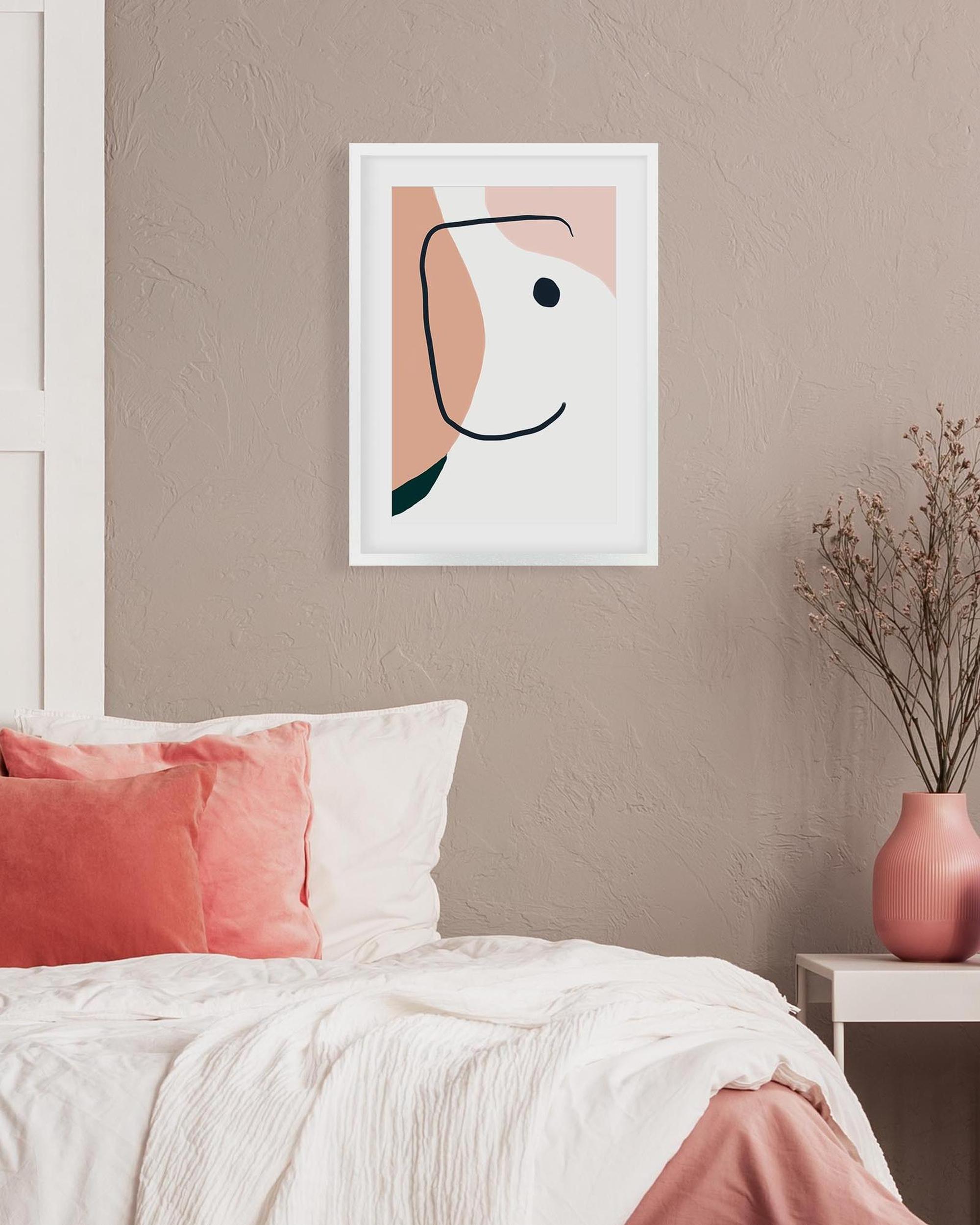 Abstract art print on a wall above a bed with pink and white bedding.