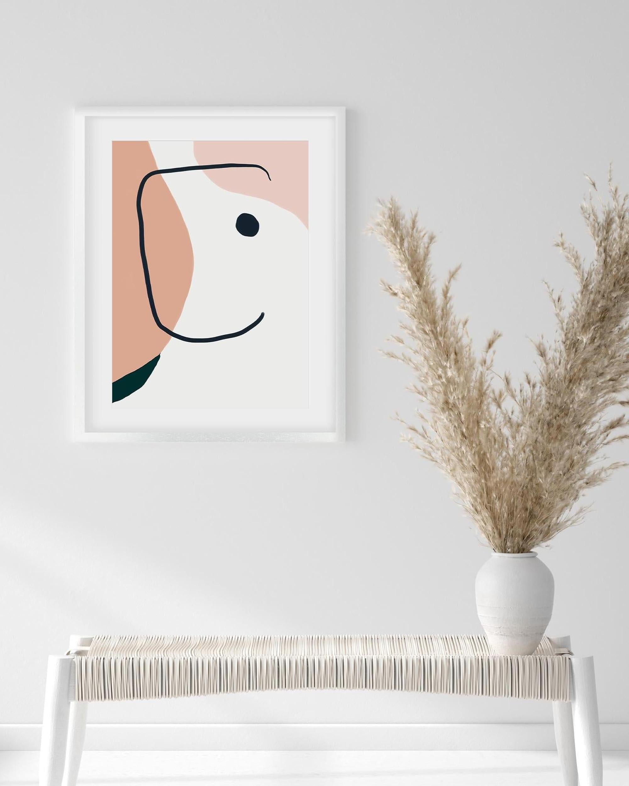 Framed abstract art print on a white wall with a vase of dried plants below.
