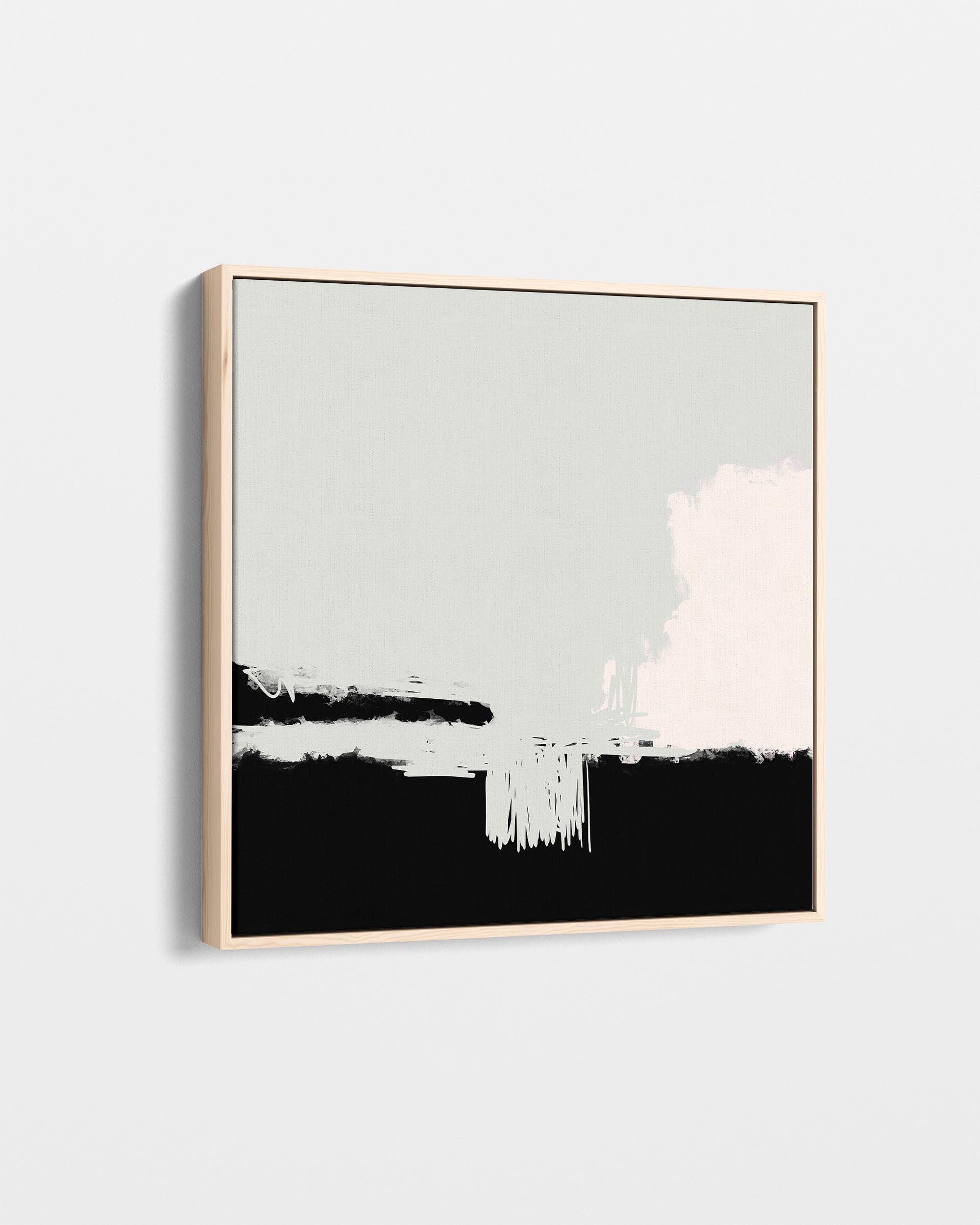 Abstract art print with black, white, and gray brush strokes in a gold frame on a light gray background