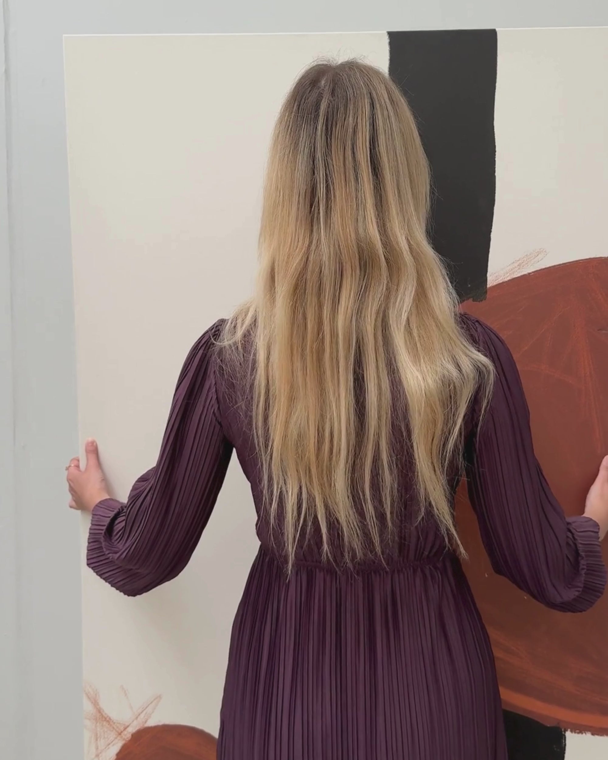 woman hanging an extra large abstract canvas
