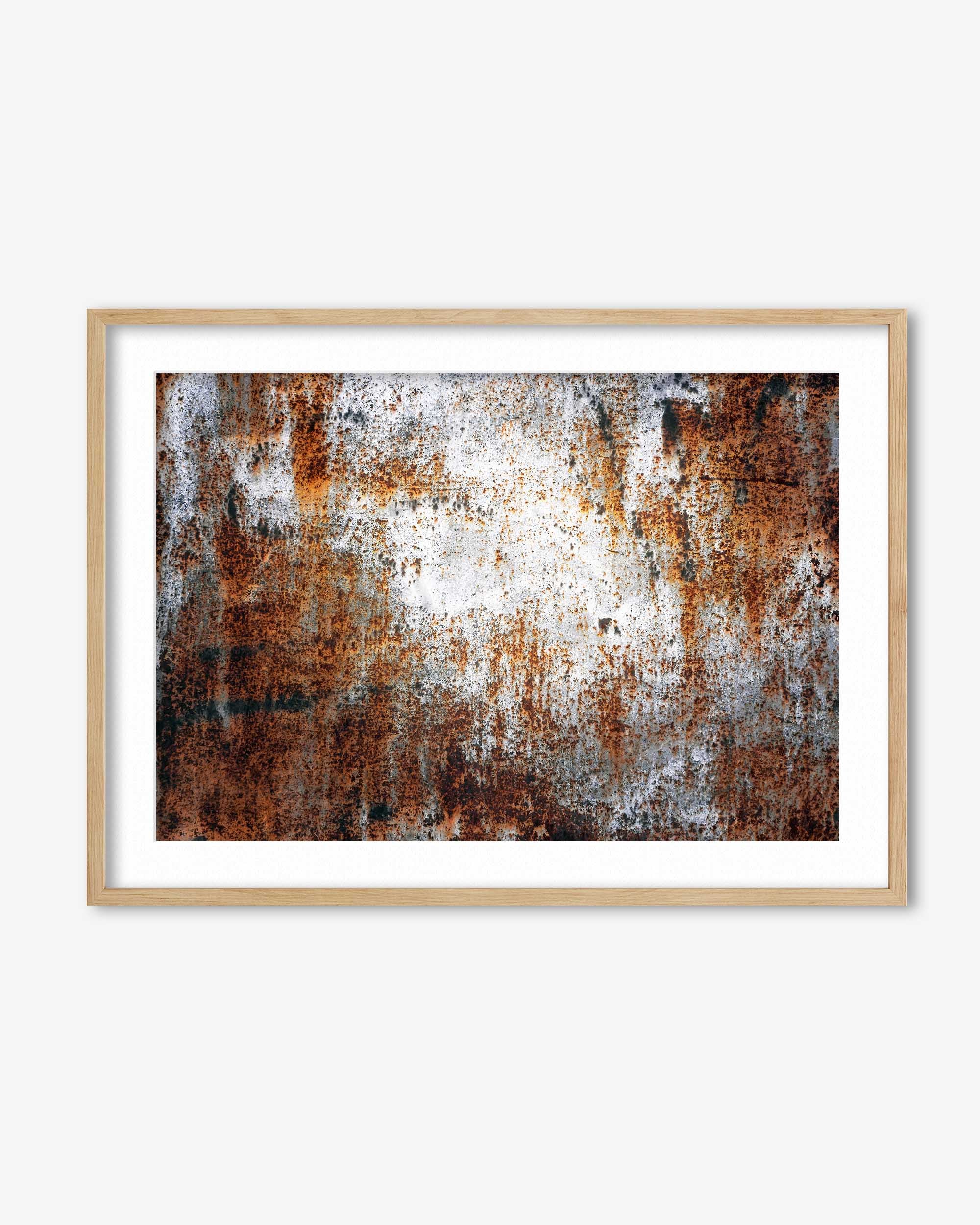 Framed abstract art with rust-like textures on a white background