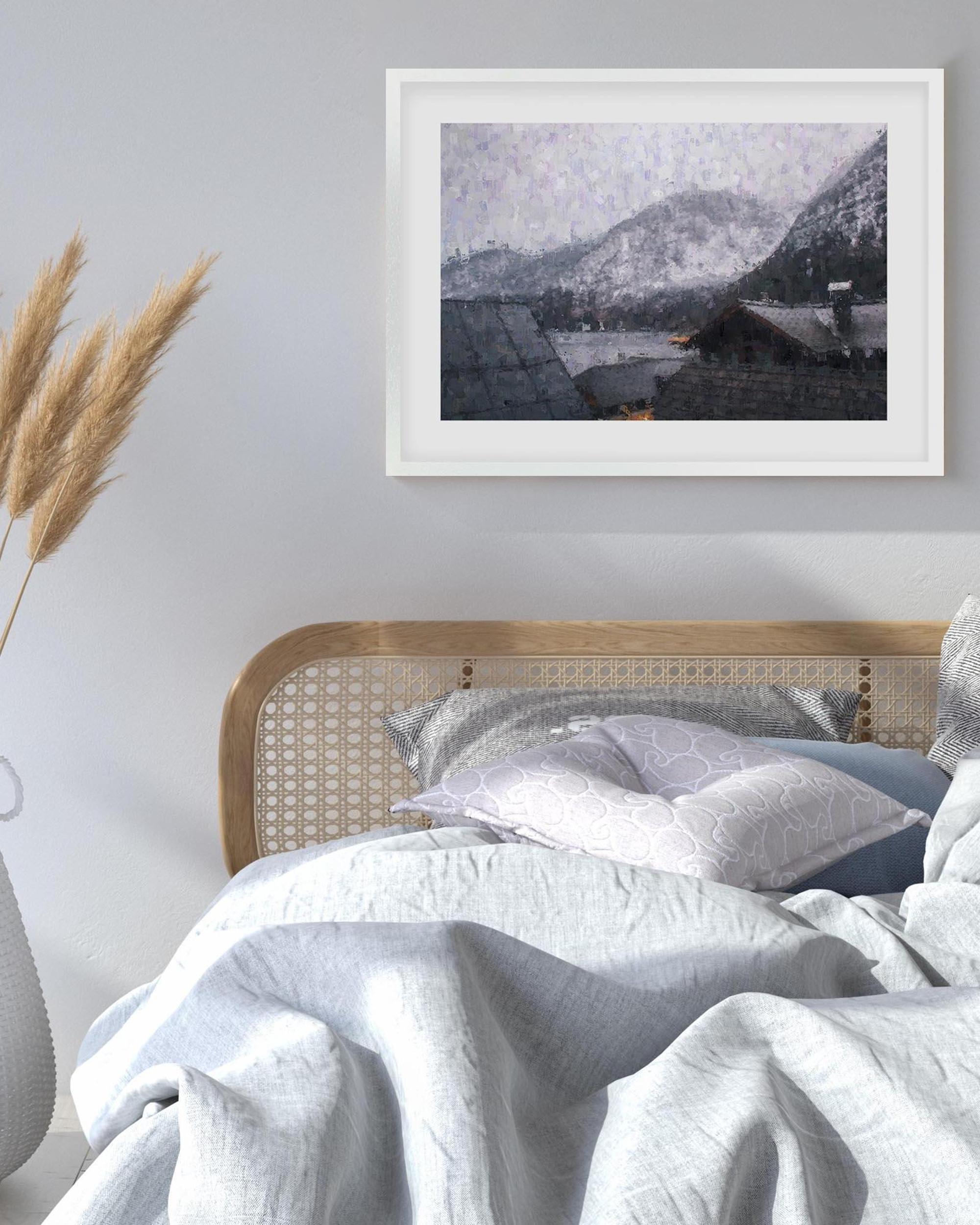 Framed mountain landscape print above a bed with white bedding.