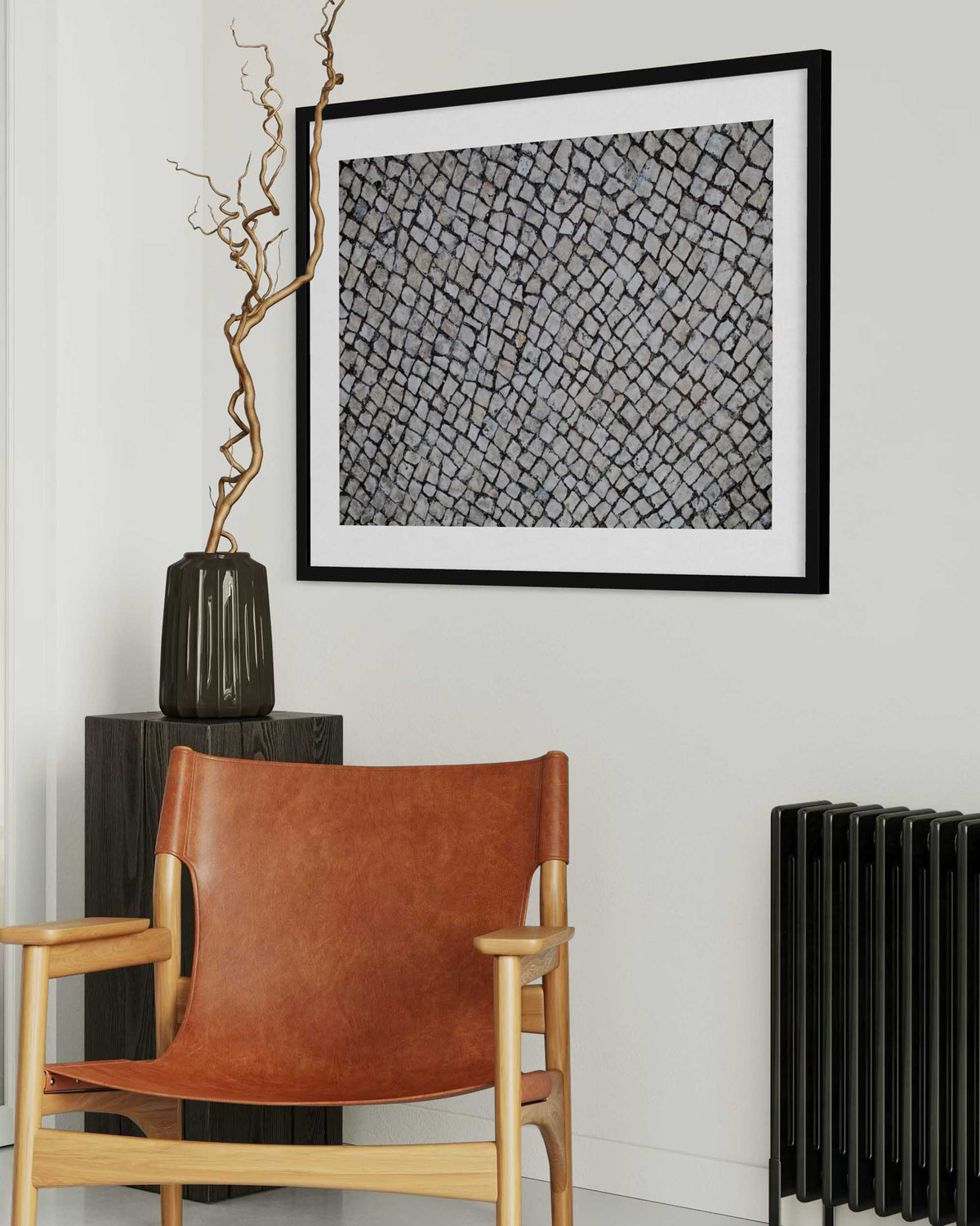 Brown leather chair in a room with a black and white abstract art piece on the wall.