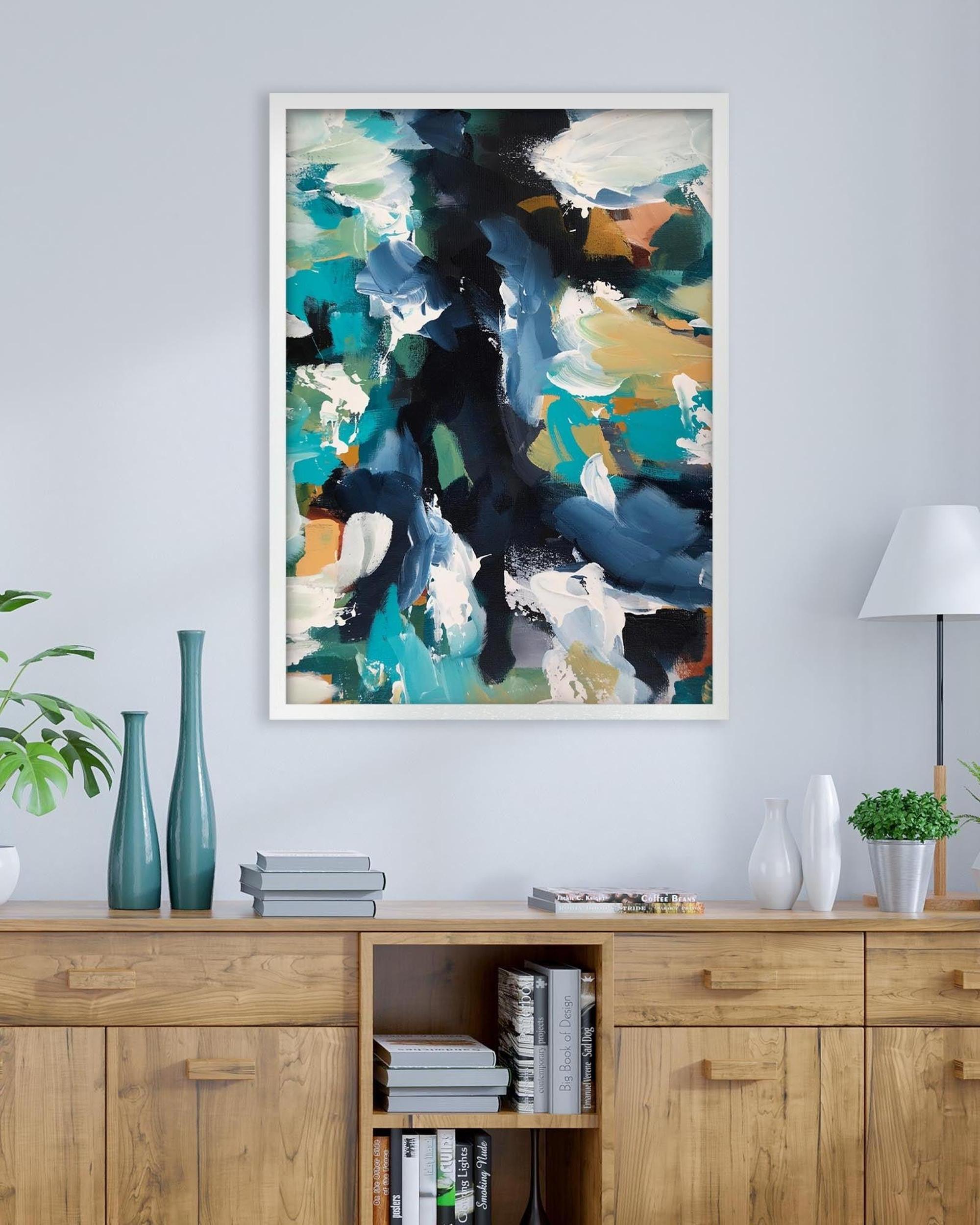 Abstract art print on a wall above a wooden cabinet with decorative items.