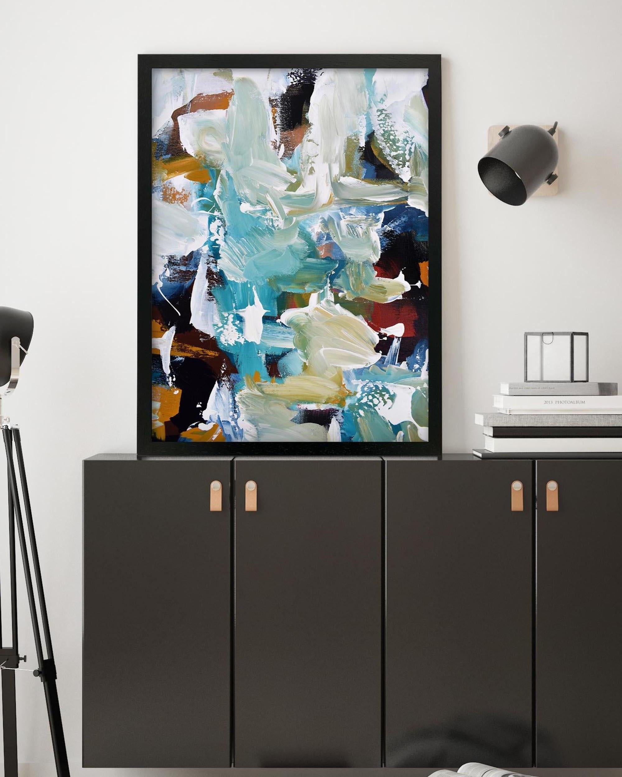 Abstract painting on a wall above a black cabinet with wooden handles.