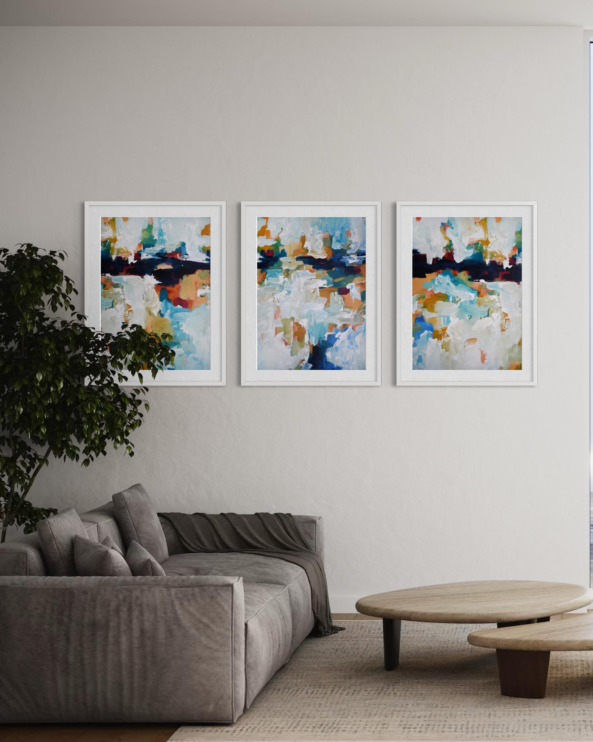 Three abstract paintings on a wall above a sofa in a living room.