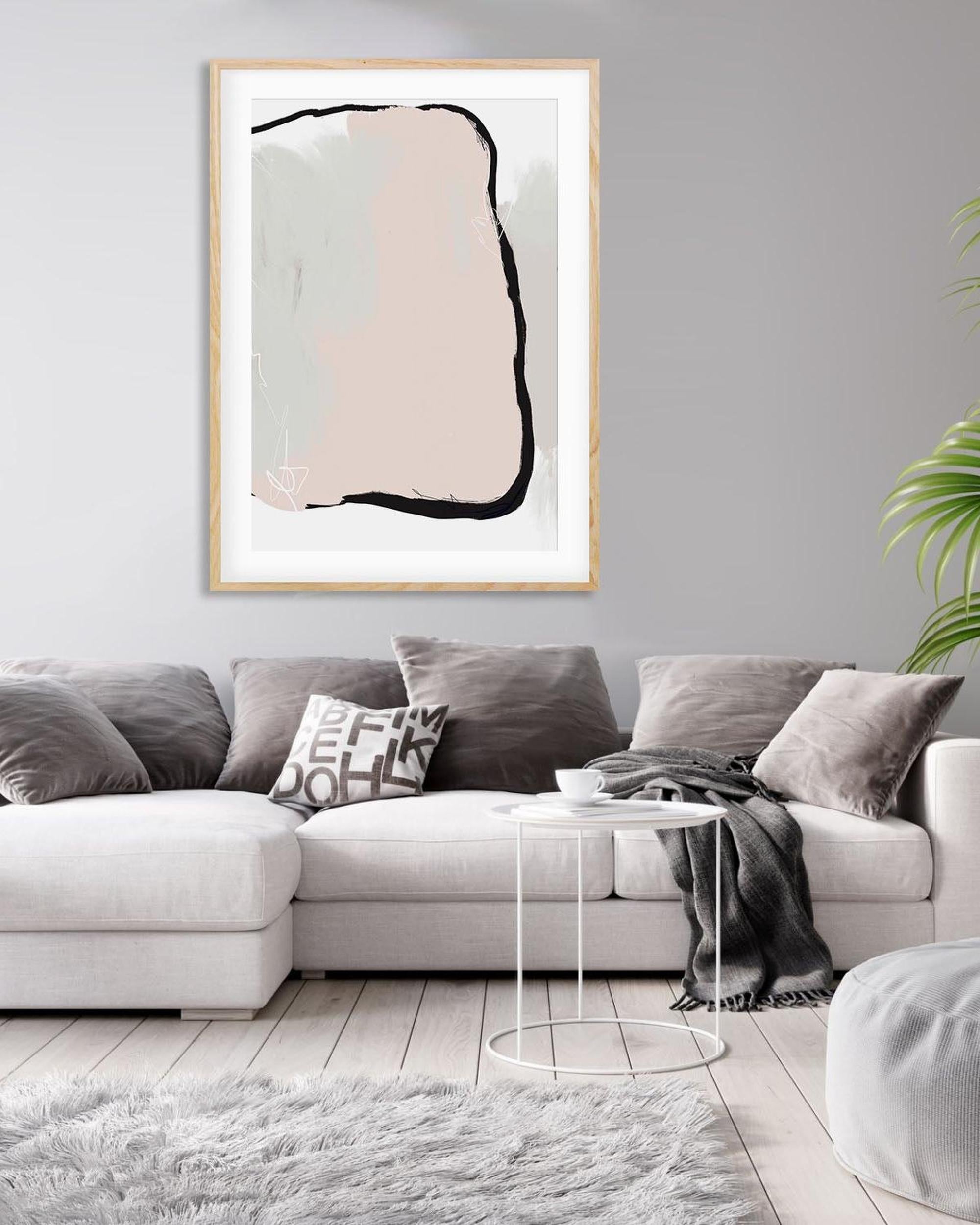 Living room with a gray sectional sofa, abstract art on the wall, and a small round table.