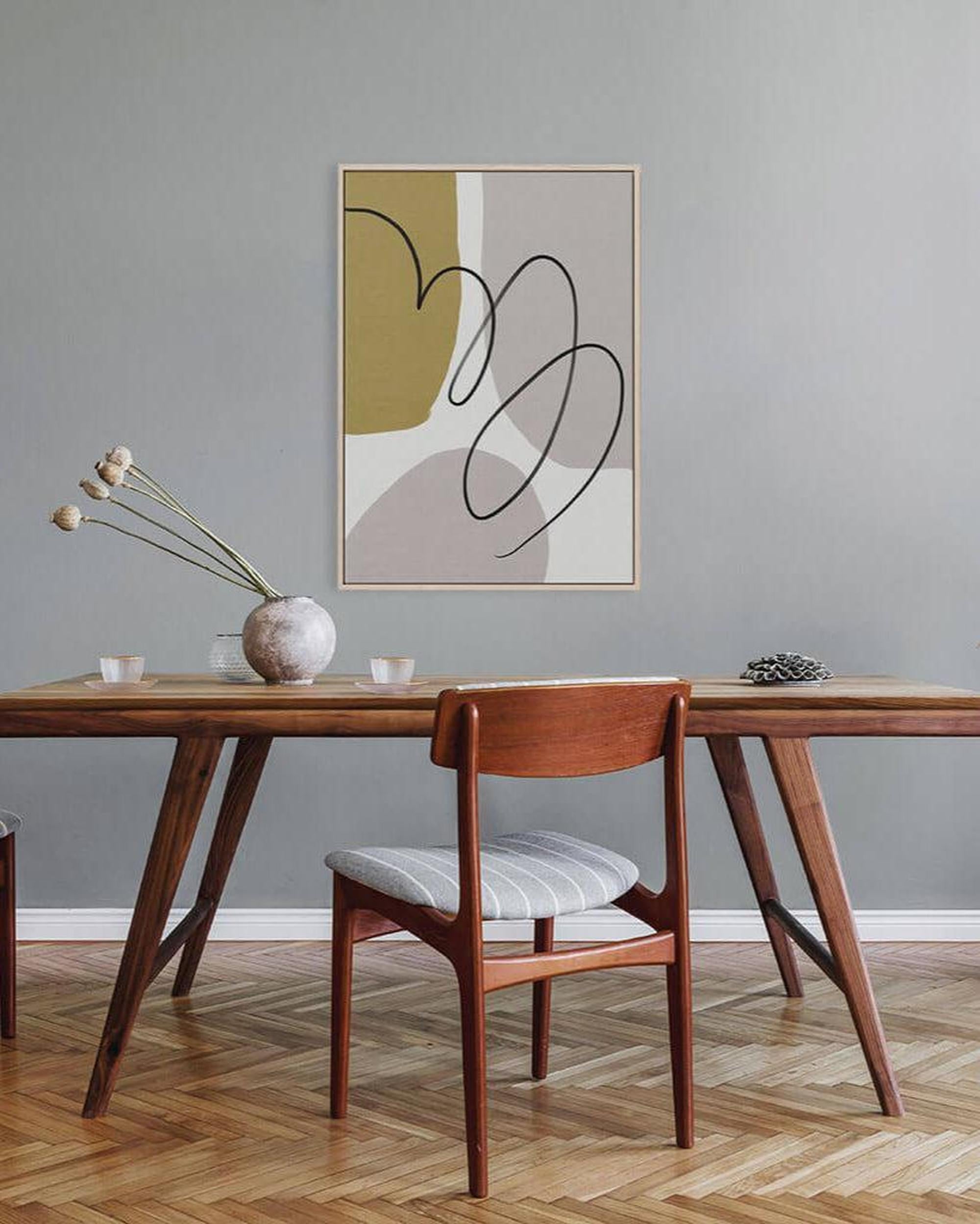 Dining room with wooden table and chairs, abstract art on the wall.