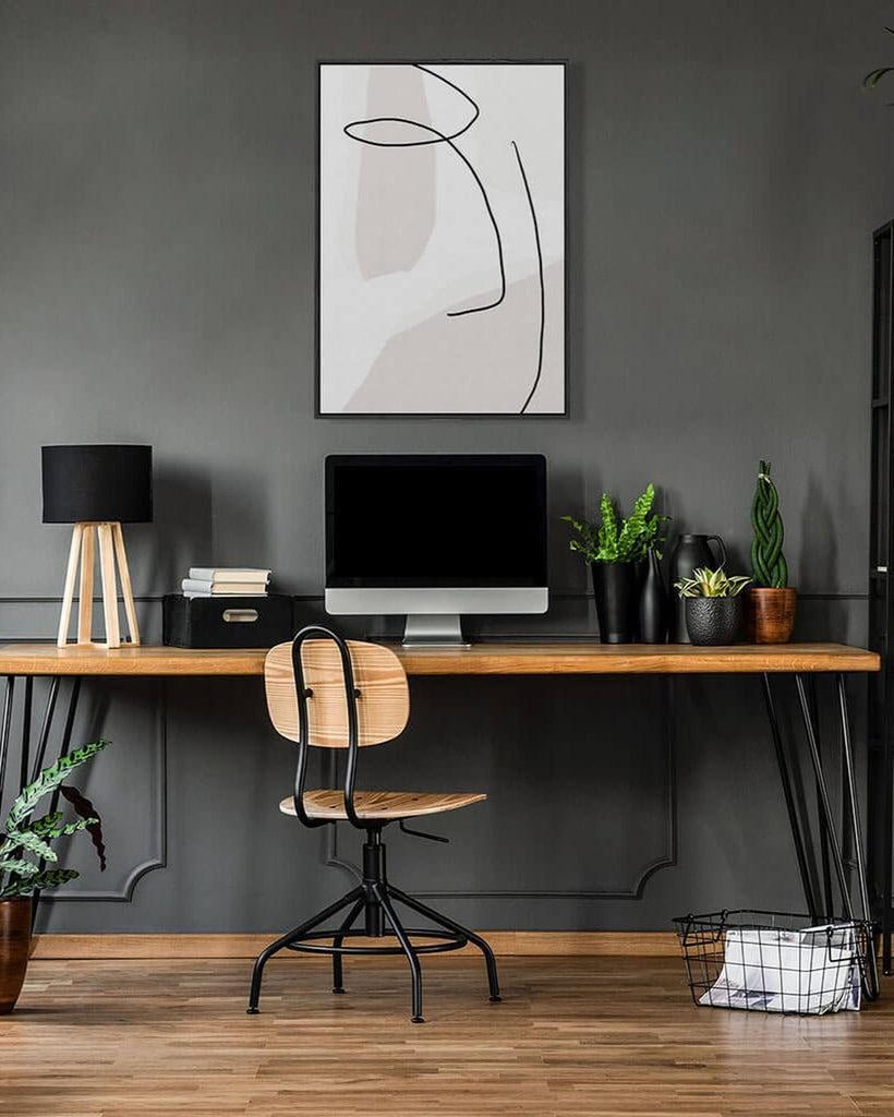Modern home office with a wooden desk, chair, and decorative elements.